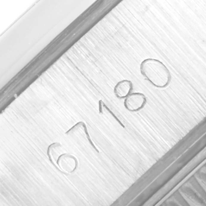 This close-up image shows the serial number engraved on the side of a Rolex Oyster Perpetual 67180 Women's Stainless Steel Black Dial 67180 Women's Stainless Steel Black Dial watch case.
