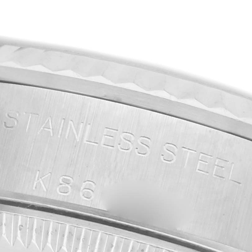 The image shows a close-up of the engraved stainless steel case of a Rolex Oyster Perpetual 76094 Women's Stainless Steel Silver Dial 76094 Women's Stainless Steel Silver Dial watch.