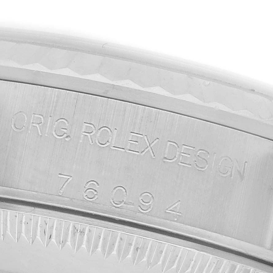 The image shows a close-up of the case side of a Rolex Oyster Perpetual 76094 Women's Stainless Steel Silver Dial 76094 Women's Stainless Steel Silver Dial, highlighting the engraved design and model number.