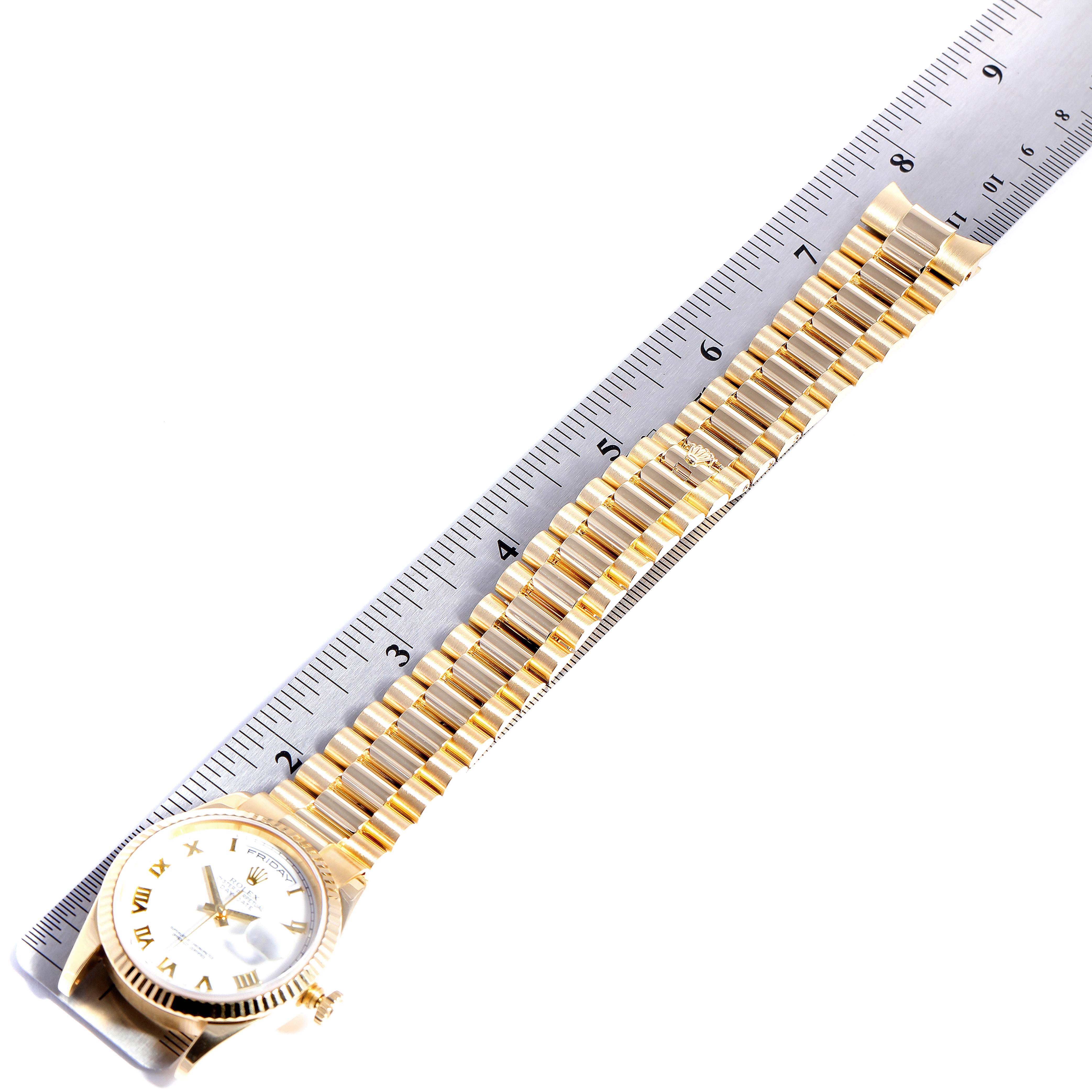 The image shows a Rolex President 118238 Men
s Yellow Gold White Dial 118238 Men
s Yellow Gold White Dial watch laid flat, with the face and bracelet aligned along a ruler.