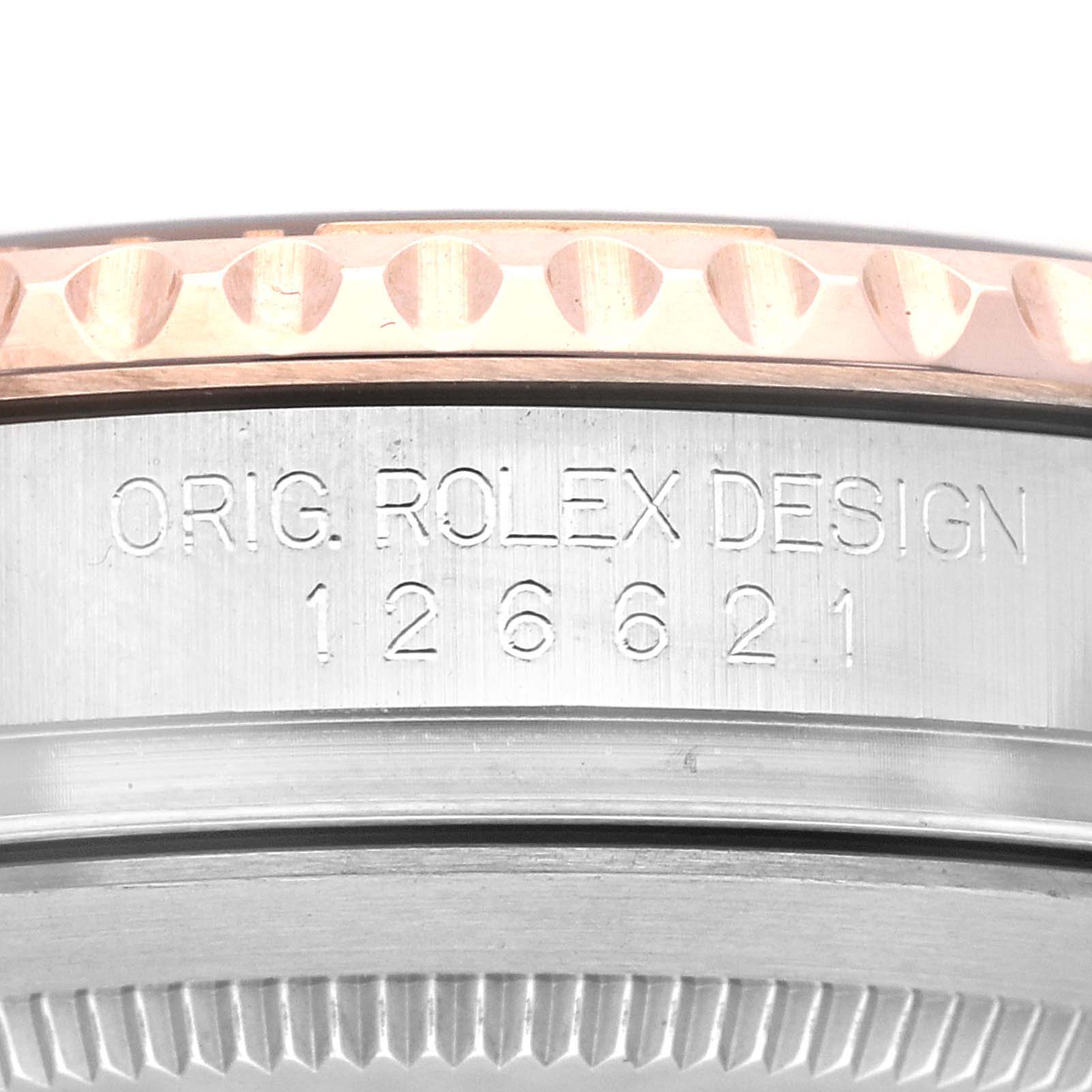 The image shows a close-up of the side of a Rolex Yacht-Master 126621 Men's Steel and Gold (two tone) Black Dial 126621 Men's Steel and Gold (two tone) Black Dial watch case, featuring the engraving "ORIG. ROLEX DESIGN 126621".