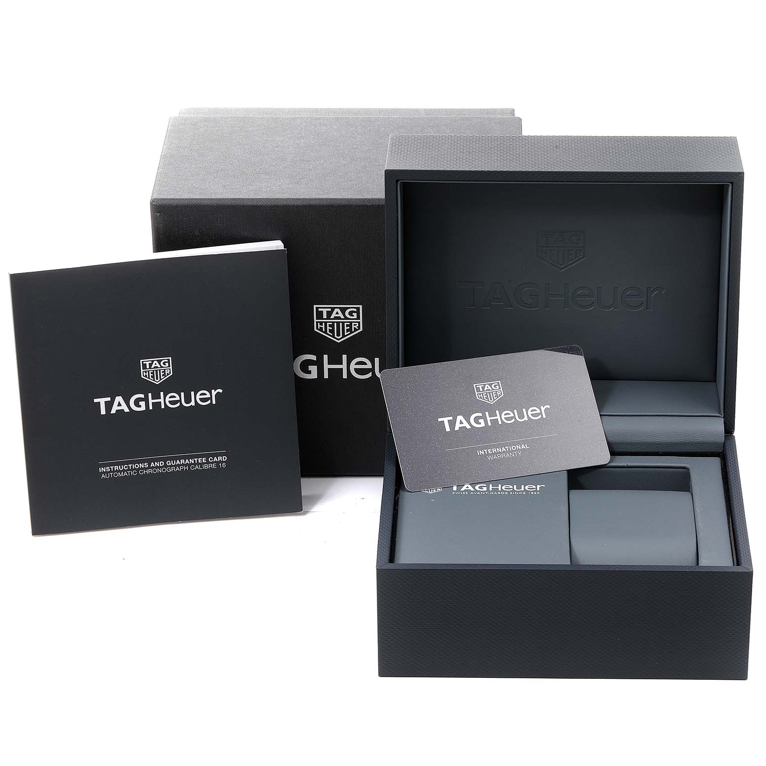 The image shows packaging and accessories for a Tag Heuer Carrera CBM2110 Men
s Stainless Steel Black Dial CBM2110 Men
s Stainless Steel Black Dial watch, including the box, booklet, and warranty card.
