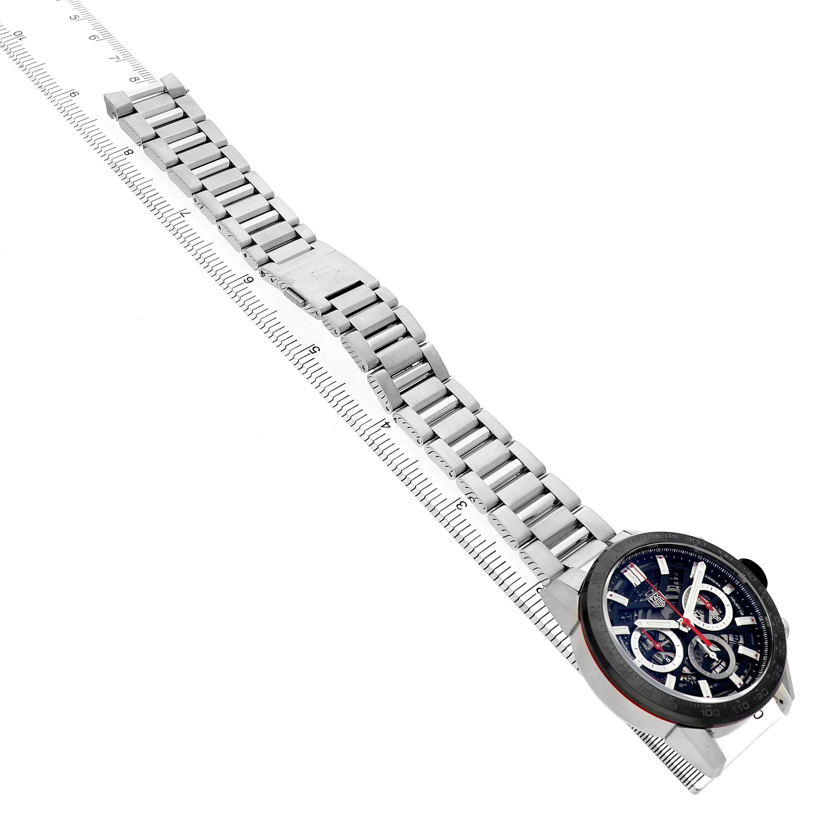 The Tag Heuer Carrera CBG2010 Men's Stainless Steel Black Dial watch is shown from a diagonal angle, highlighting the face and full metal bracelet with a ruler for scale.