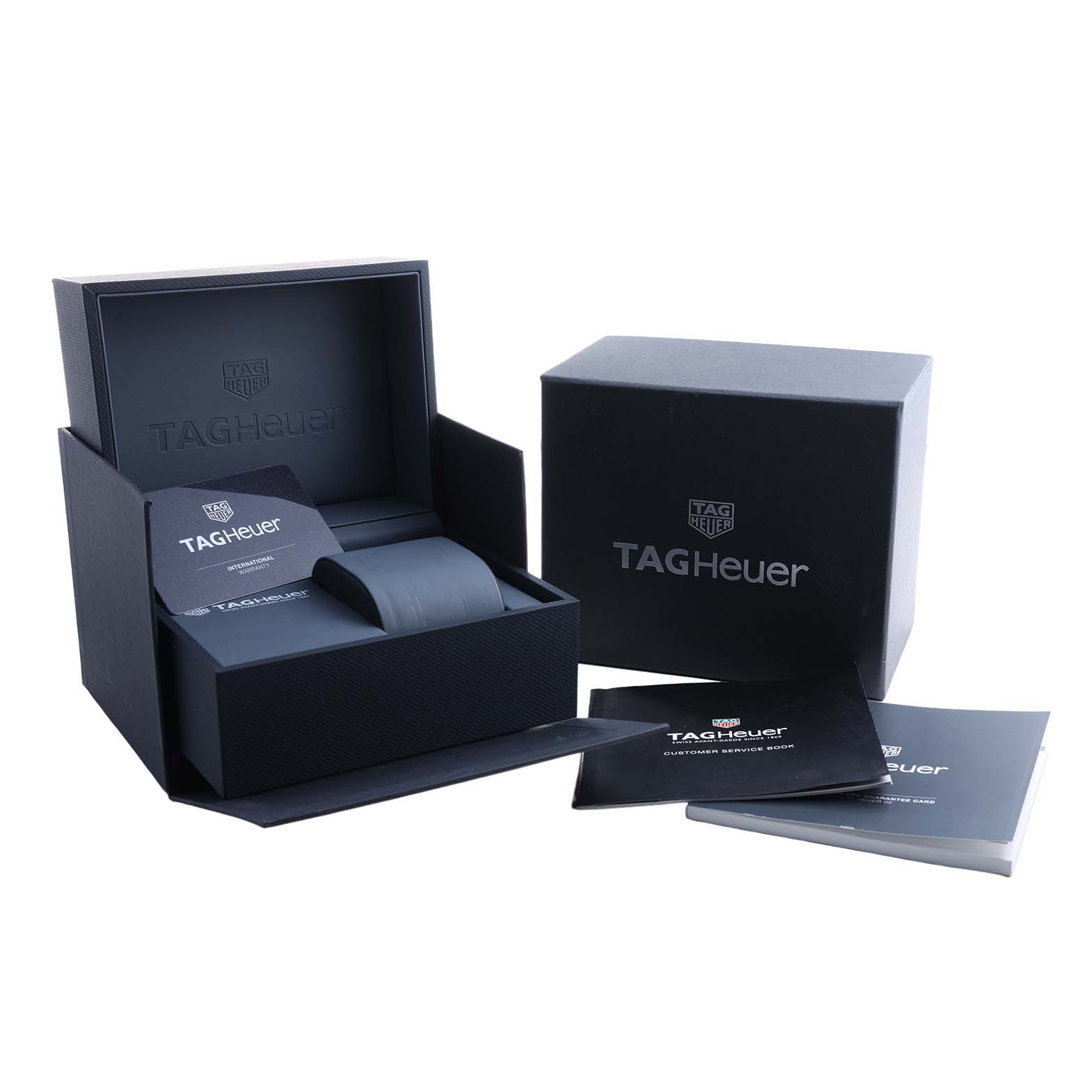 The image shows a TAG Heuer Carrera watch box, user manuals, and packaging from a slightly elevated angle.