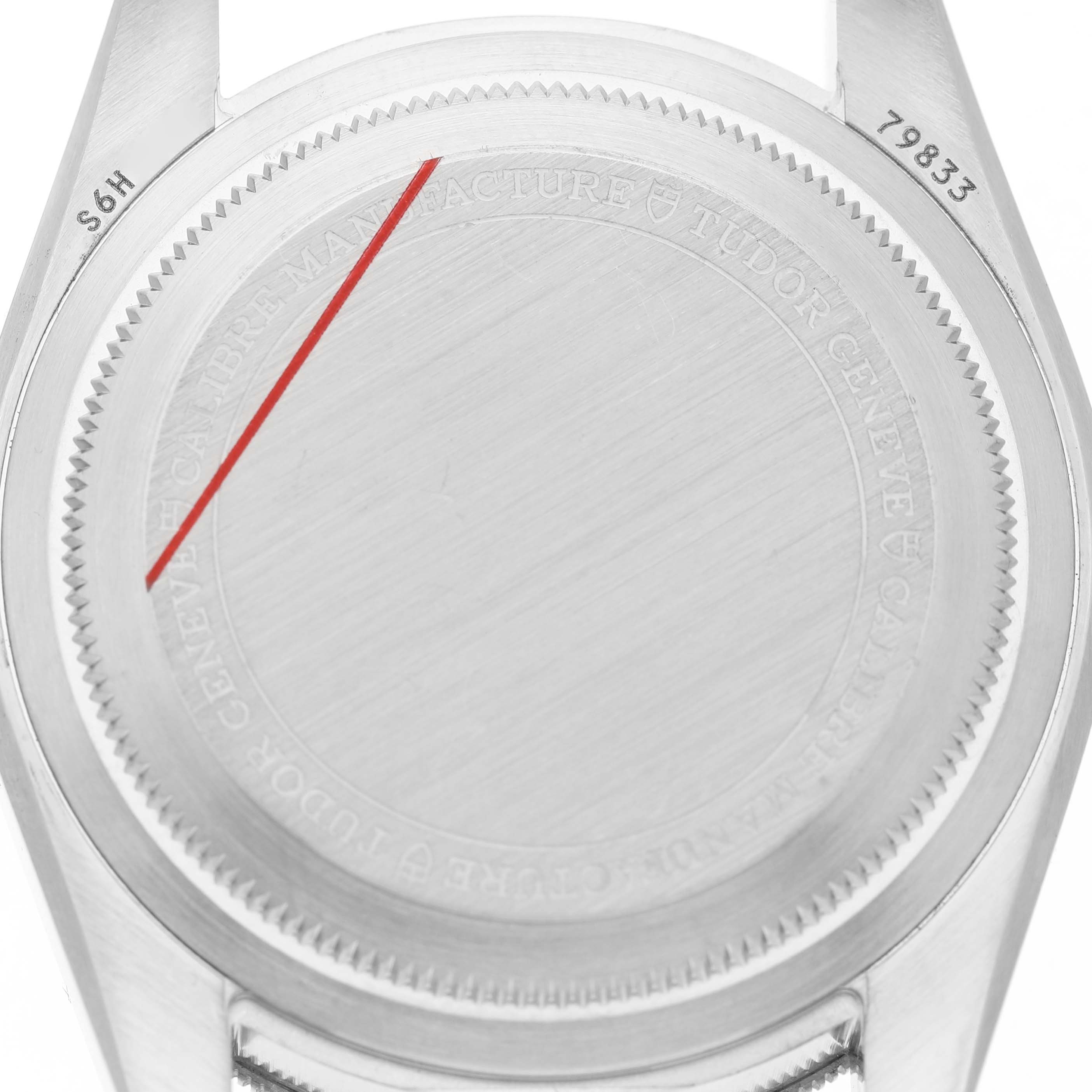 The image shows the case back of the Tudor Heritage Black Bay 79833MN Men's Steel and Gold (two tone) Black Dial watch from a top-down angle, featuring engravings and lugs.