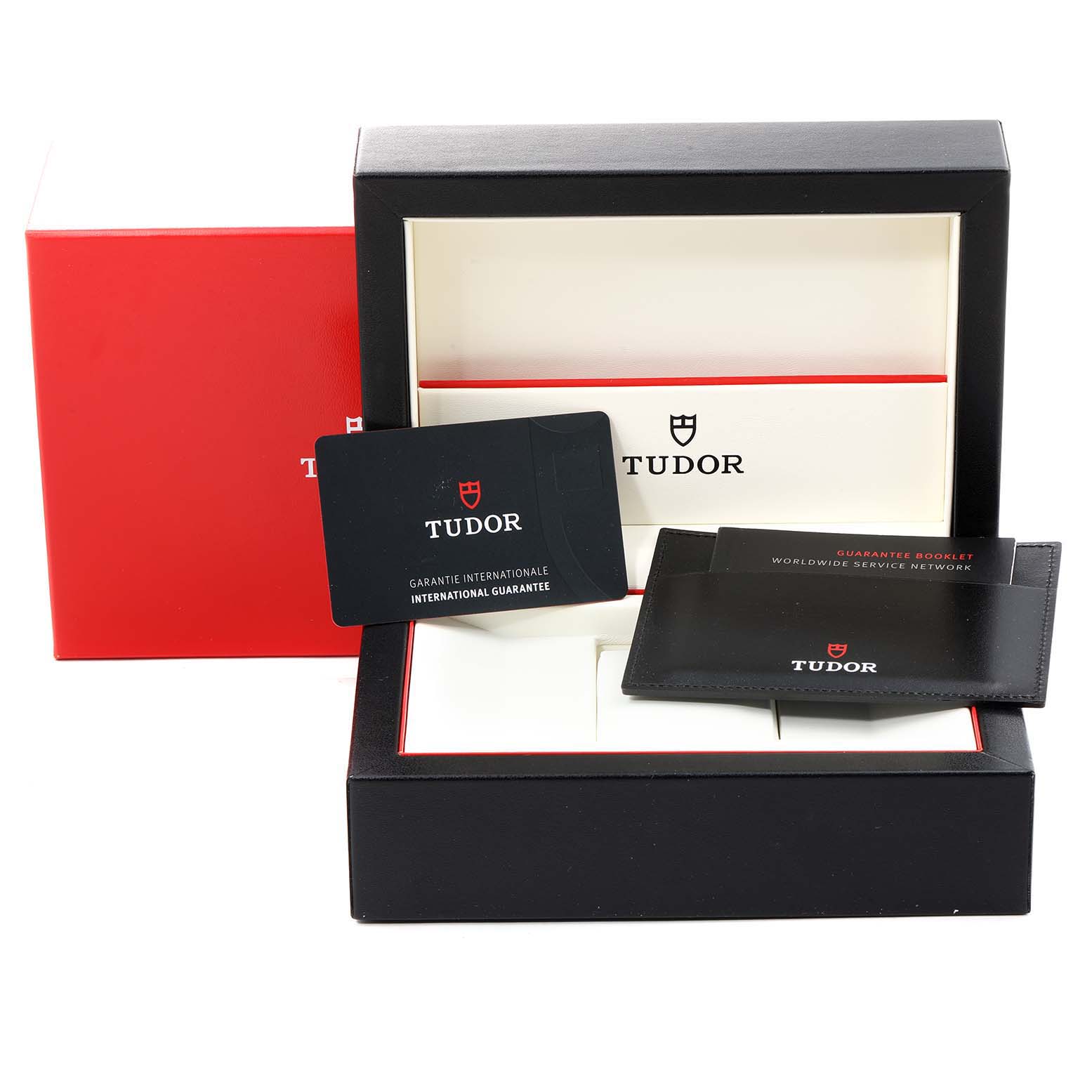The image shows the packaging and warranty cards of the Tudor Style M12300-0004 Women's Stainless Steel Black Dial M12300-0004 Women's Stainless Steel Black Dial model, including an open box and guarantee booklet.