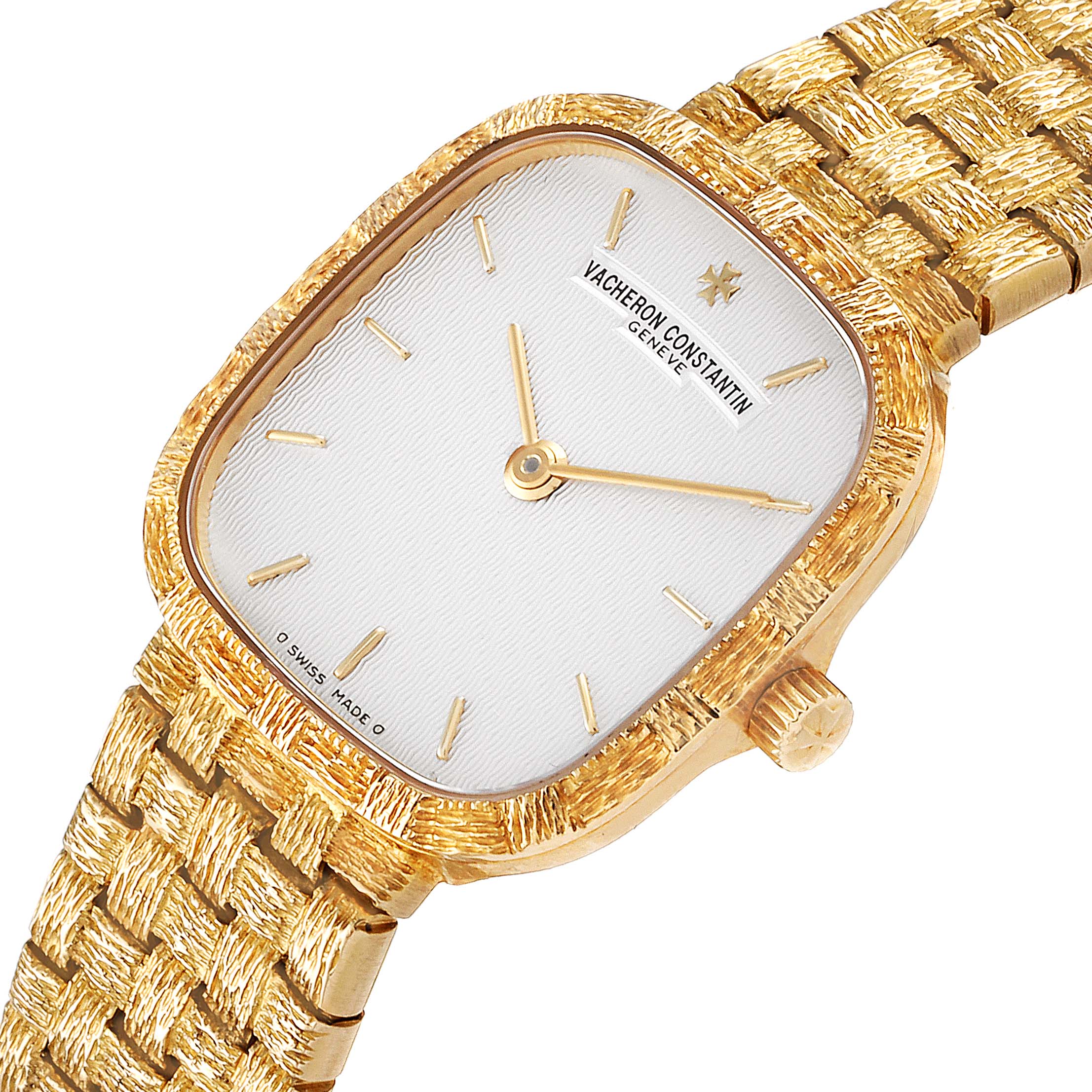 The image shows a close-up angle of a vintage Vacheron Constantin watch, highlighting its gold case, white dial, and textured gold bracelet.