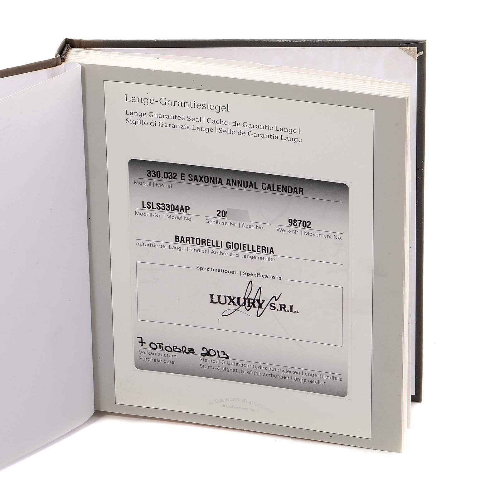 The image displays the warranty booklet for the Saxonia model by A. Lange 
Söhne, shown from an angled top-down view.