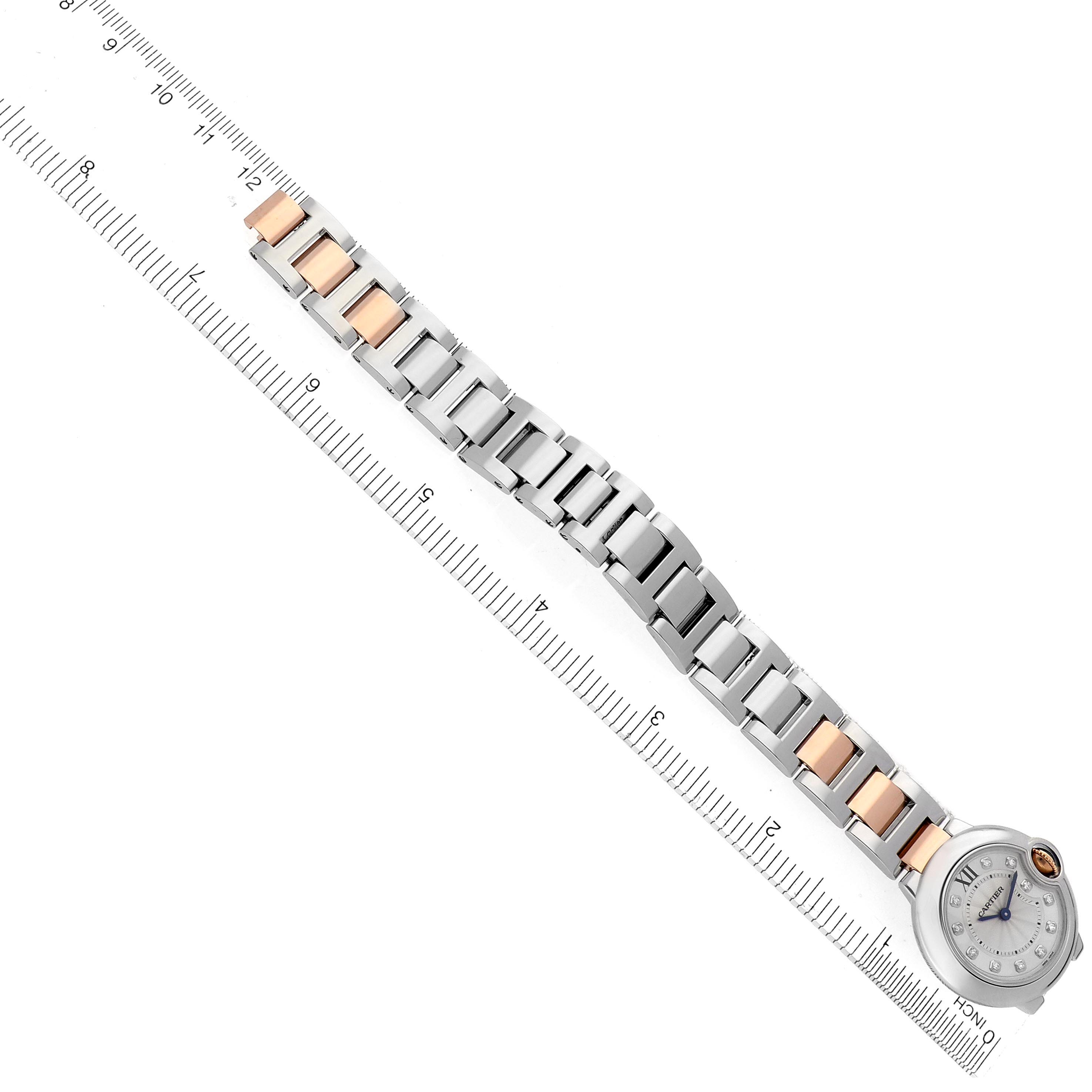 The image shows a Cartier Ballon Bleu WE902030 Women
s Steel and Gold (two tone) Silver Dial WE902030 Women
s Steel and Gold (two tone) Silver Dial watch laid flat, with its bracelet and face visible alongside a measuring ruler.