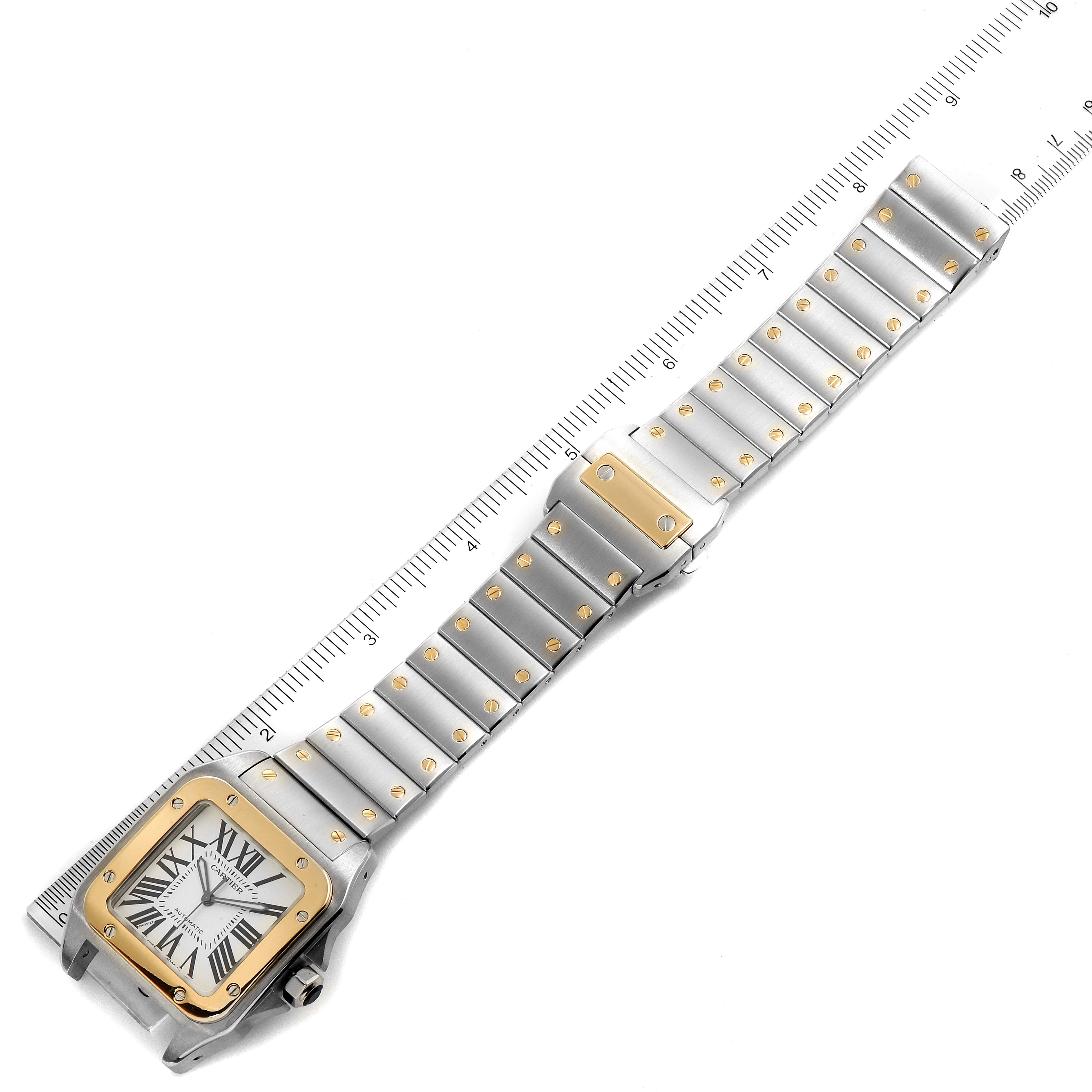 The image shows a Cartier Santos W200728G  Men's Steel and Gold (two tone) Silver Dial W200728G  Men's Steel and Gold (two tone) Silver Dial watch placed on a measuring scale, displaying the face and full bracelet.
