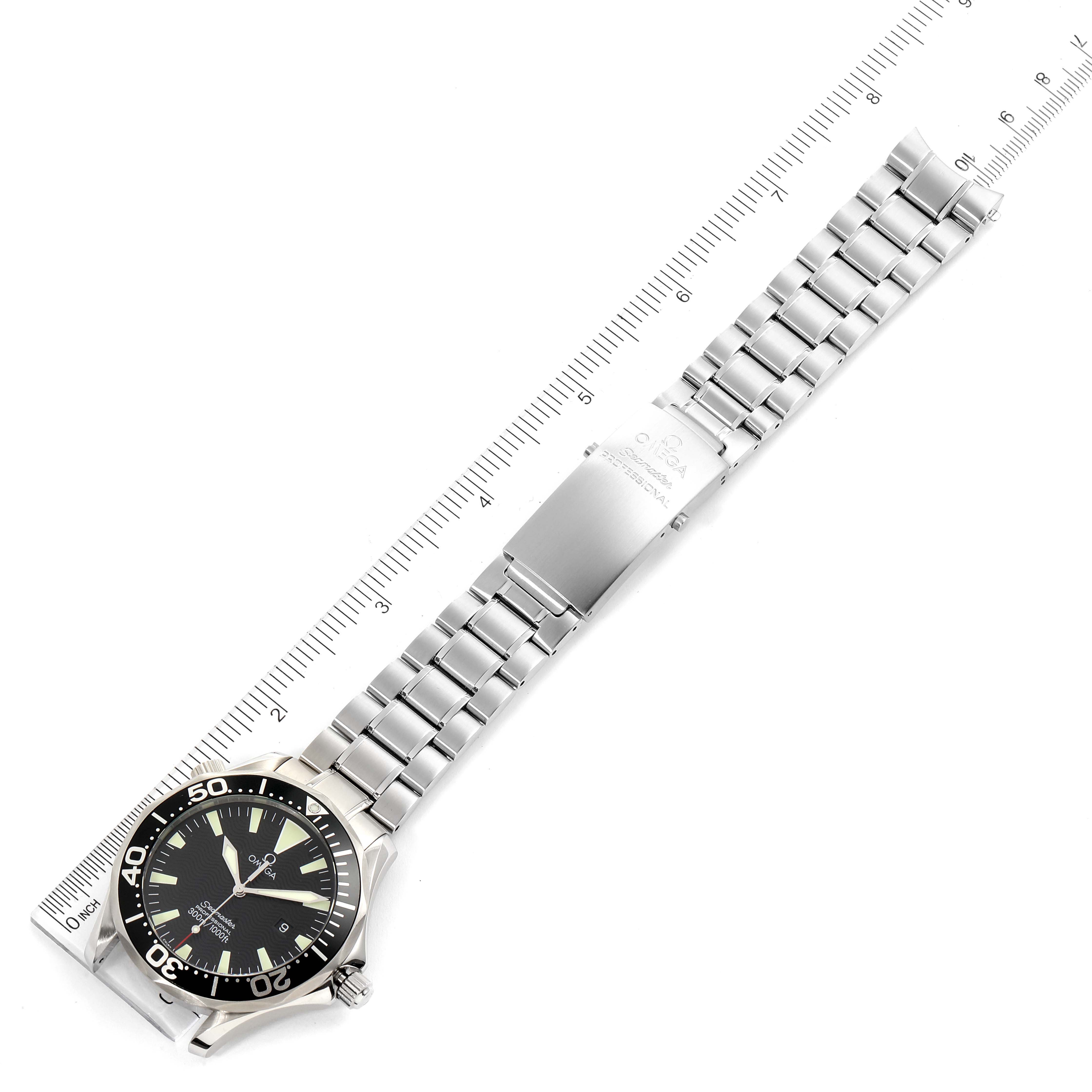 The image shows the entire Omega Seamaster 2264.50.00 Men
s Stainless Steel Black Dial 2264.50.00 Men
s Stainless Steel Black Dial watch from an overhead angle, featuring the face, bezel, and stainless steel bracelet aligned with a ruler.