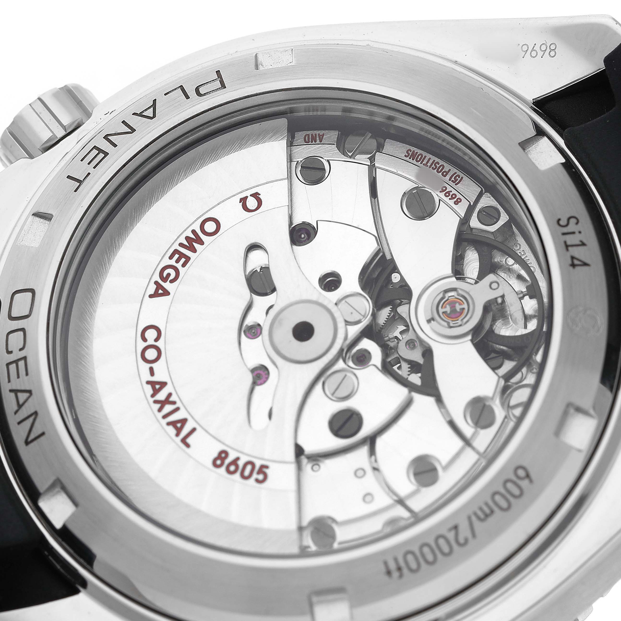 The image shows the back of an Omega Planet Ocean 232.32.44.22.01.001 Men's Stainless Steel Black Dial, highlighting its Co-Axial movement and internal mechanical parts.