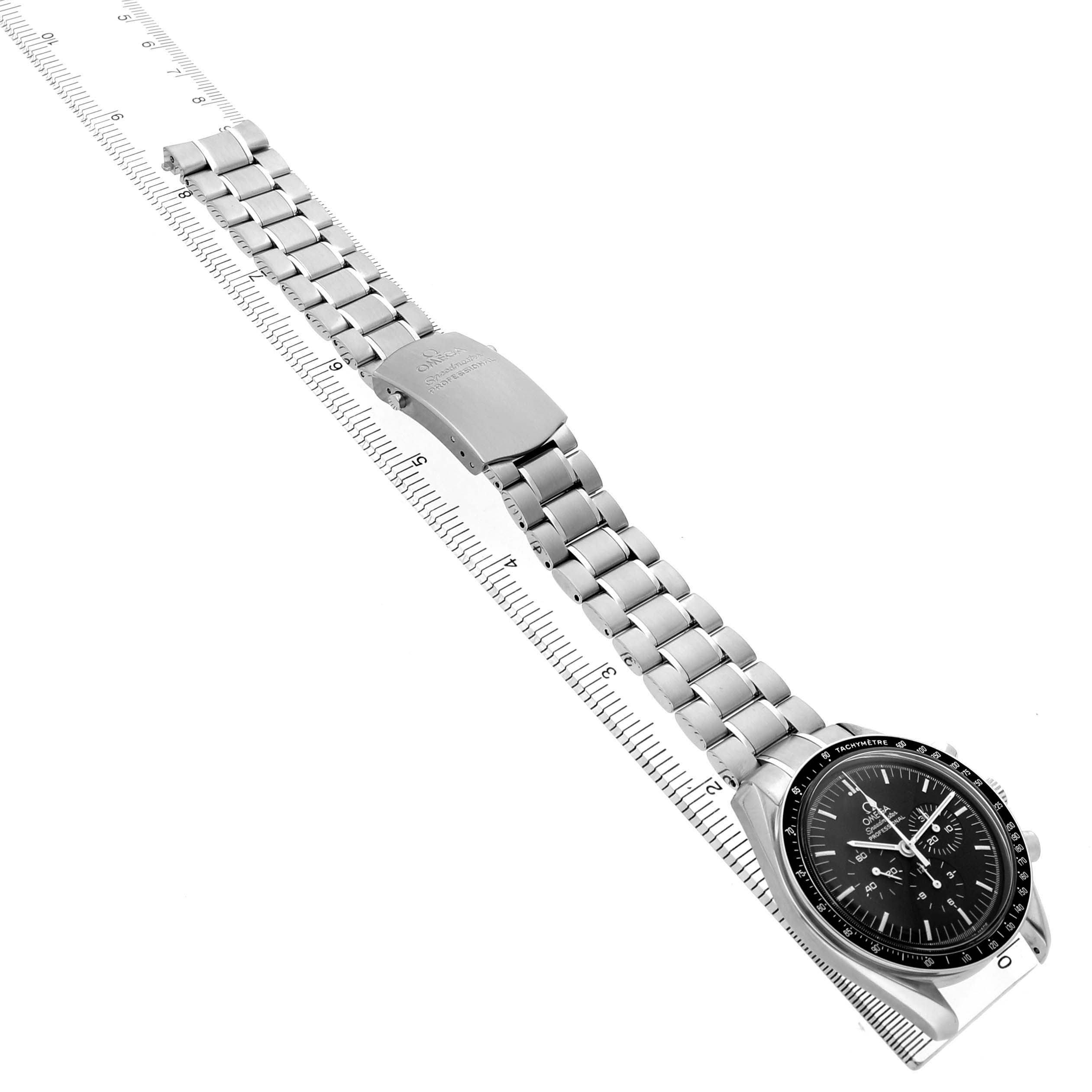 The Omega Speedmaster 3570.50.00 Men's Stainless Steel Black Dial watch is shown from an angled side view with its full bracelet and clasp extended alongside a ruler.
