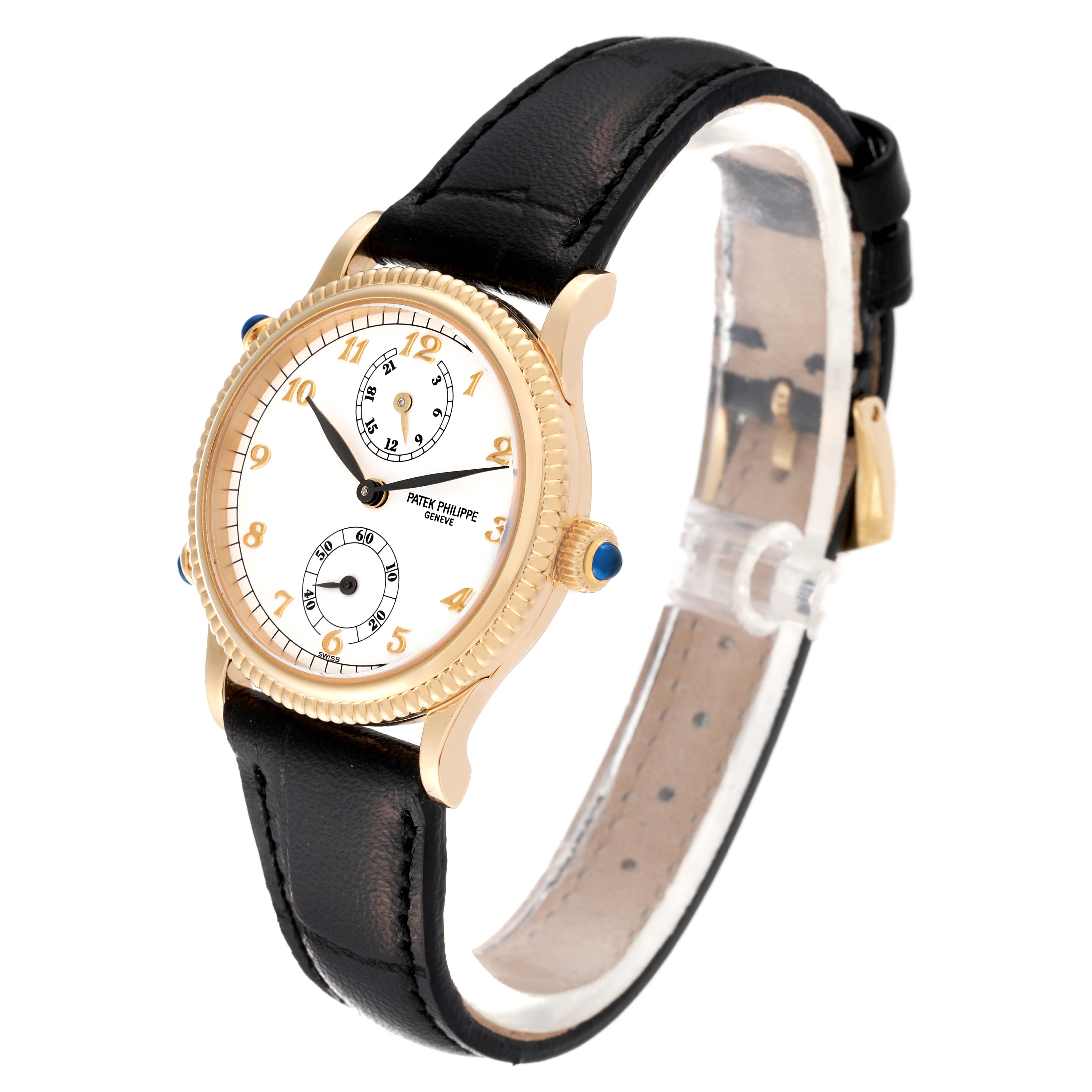 The Patek Philippe Calatrava 4864J Women's Yellow Gold White Dial 4864J Women's Yellow Gold White Dial watch is shown at a slight angle, displaying its gold casing, white dial, Arabic numerals, and black leather strap.