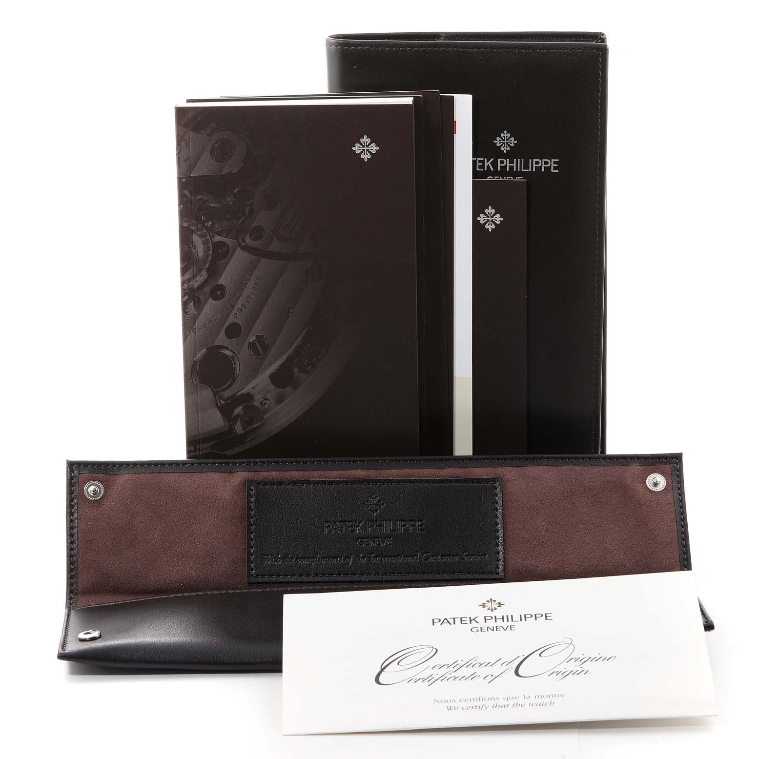 The image shows the accessories of a Patek Philippe Complications 5146G Men's White Gold Beige Dial 5146G Men's White Gold Beige Dial model, including a certificate, manuals, and a leather case.