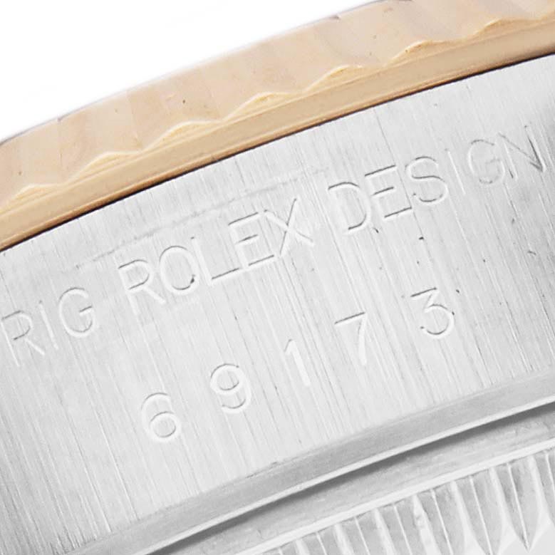 The image shows a close-up of the Rolex Date 69173 Women's Steel and Gold (two tone) Black Dial 69173 Women's Steel and Gold (two tone) Black Dial model's bezel and engraved serial number.