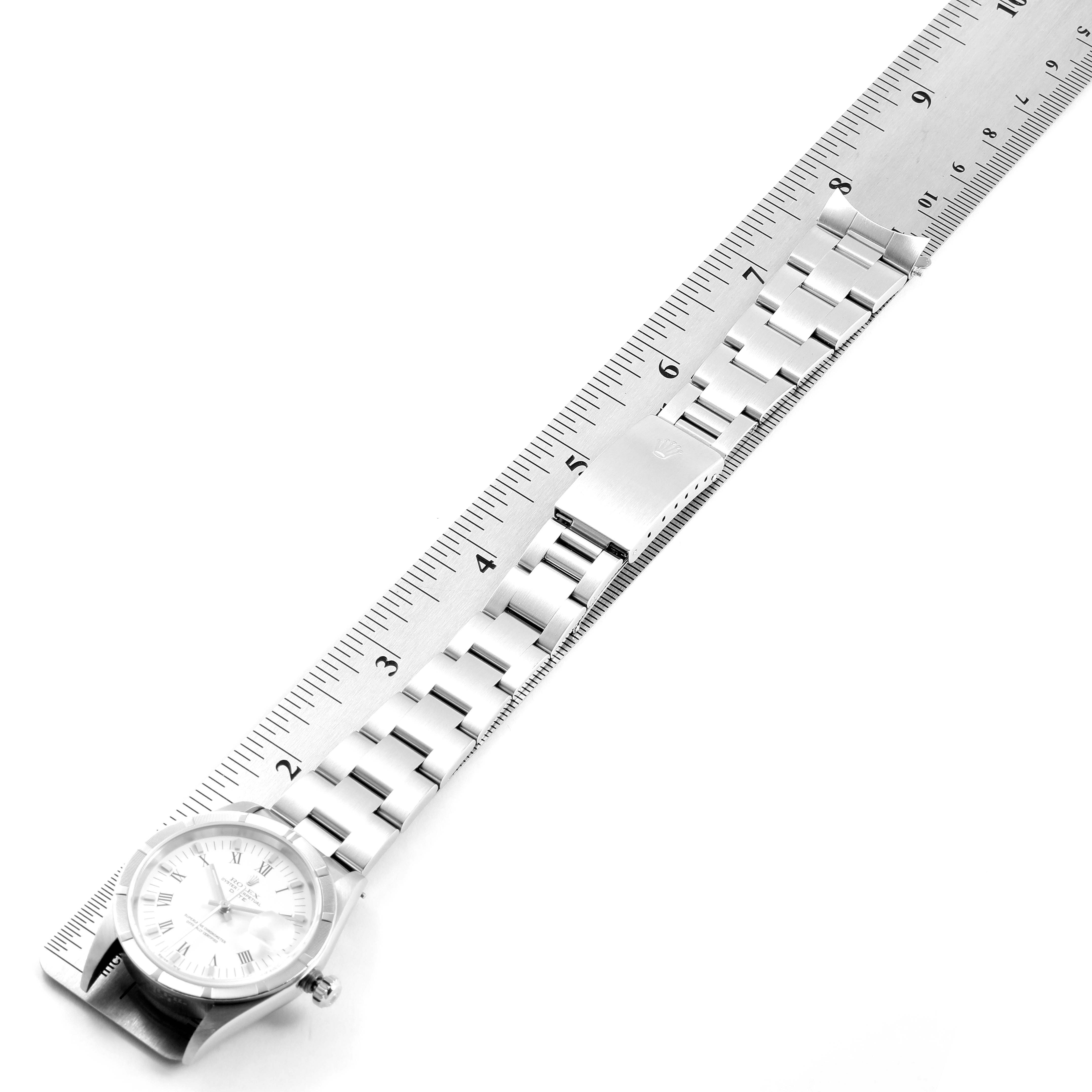 The image shows a Rolex Date 15210 Men's Stainless Steel White Dial 15210 Men's Stainless Steel White Dial model watch placed next to a ruler, displaying the watch face and metal bracelet.