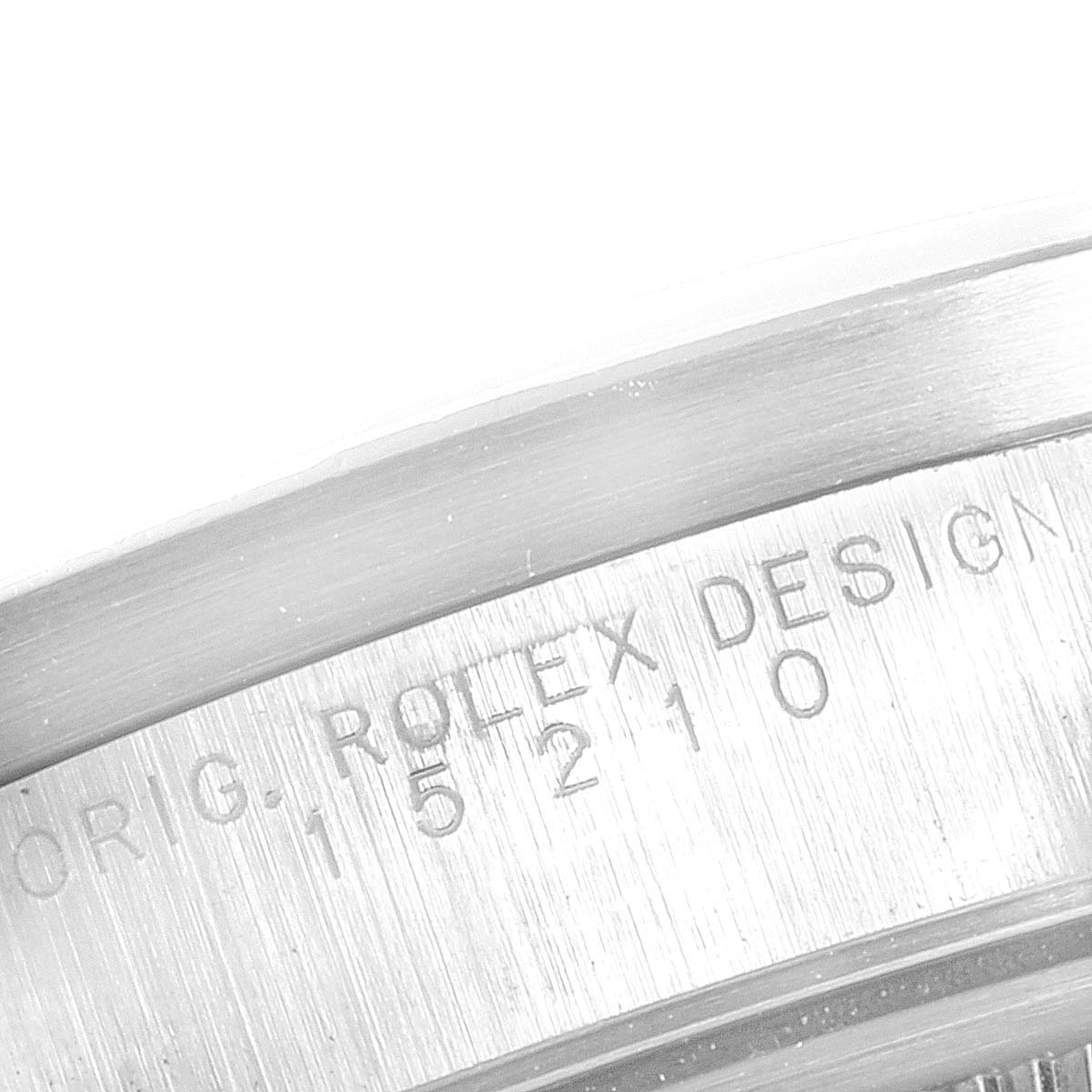 This close-up shot of the Rolex Date 15210 Men's Stainless Steel White Dial 15210 Men's Stainless Steel White Dial model shows a section of the case with engraved text and a portion of the bezel.