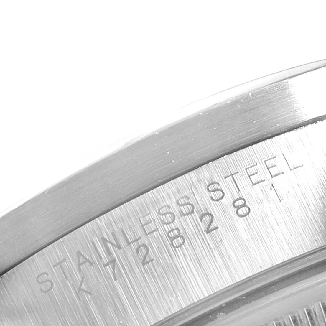 The image shows the engravings on the stainless steel bezel of a Rolex Date 15210 Men's Stainless Steel White Dial 15210 Men's Stainless Steel White Dial model watch.