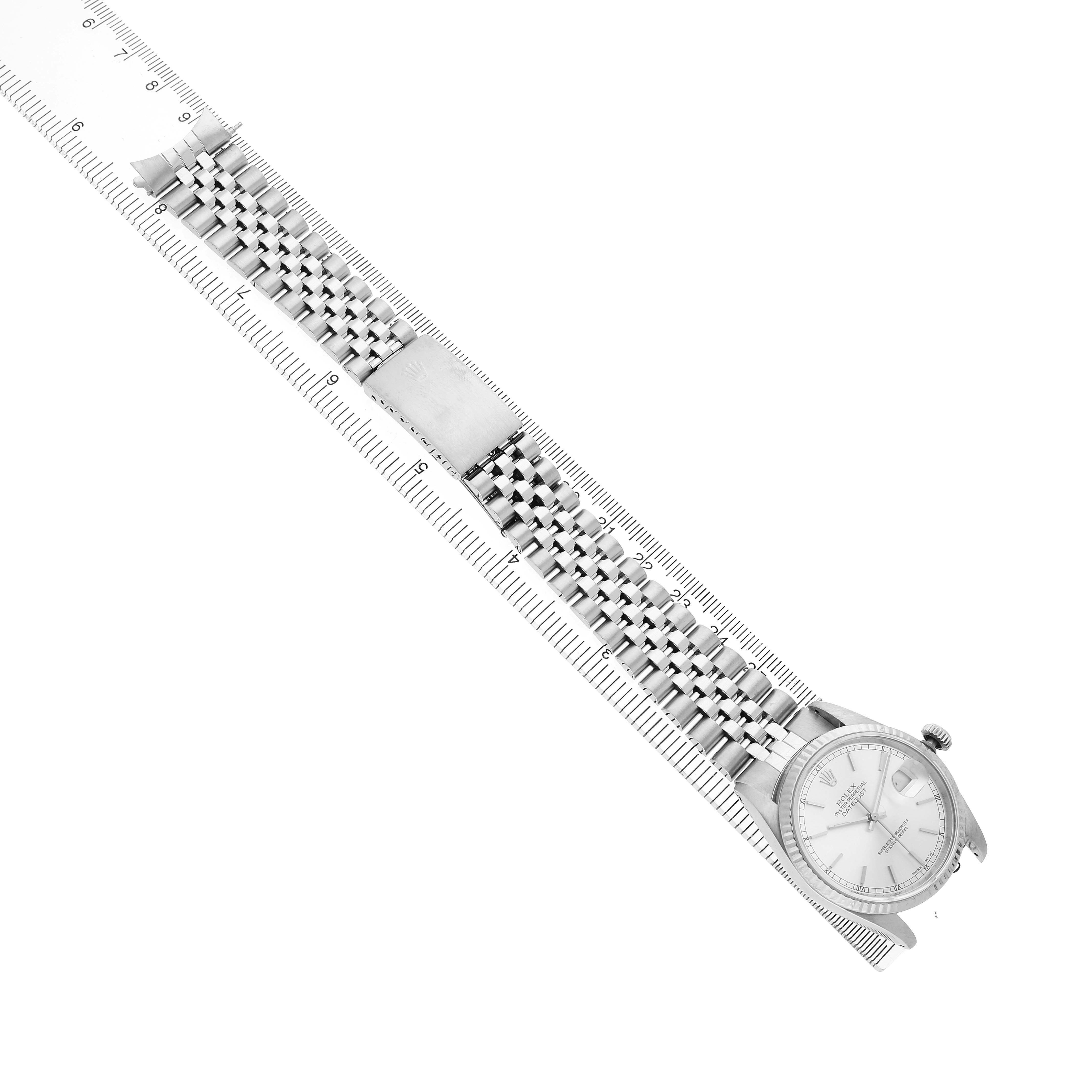 The Rolex Datejust 16234 Men's Steel and Gold (two tone) Silver Dial is displayed diagonally, showing the full bracelet, clasp, and face with a ruler for scale.