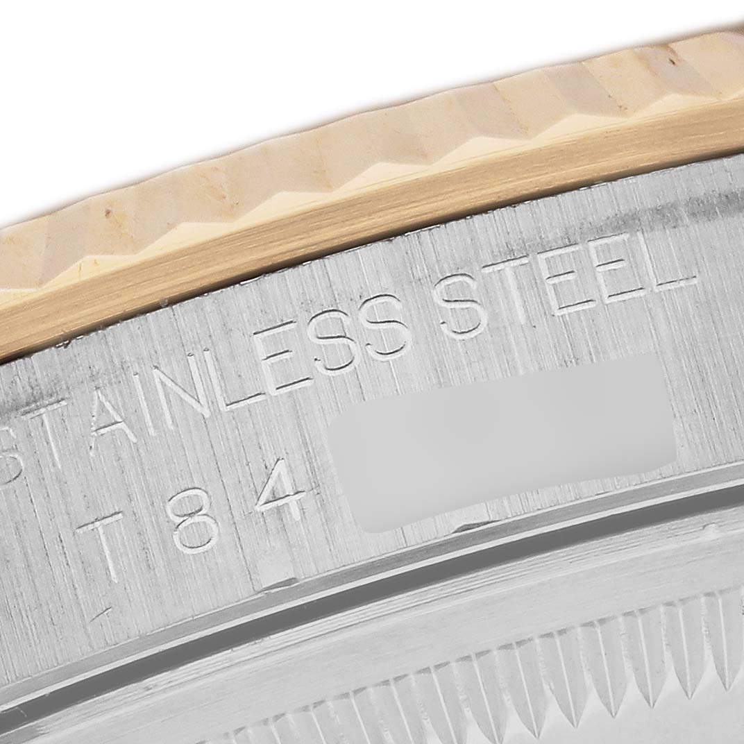 This close-up image shows the engraved case back and fluted bezel of a Rolex Datejust 16233 Men's Stainless Steel Black Dial 16233 Men's Stainless Steel Black Dial watch.