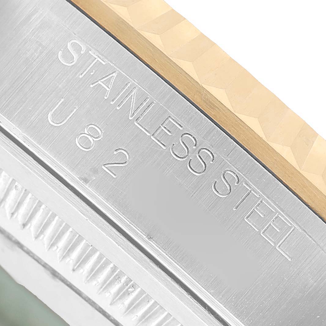 The image shows a close-up of the stainless steel side of a Rolex Datejust 16233 Men's Steel and Gold (two tone) White Dial watch, focusing on the engraved lettering.