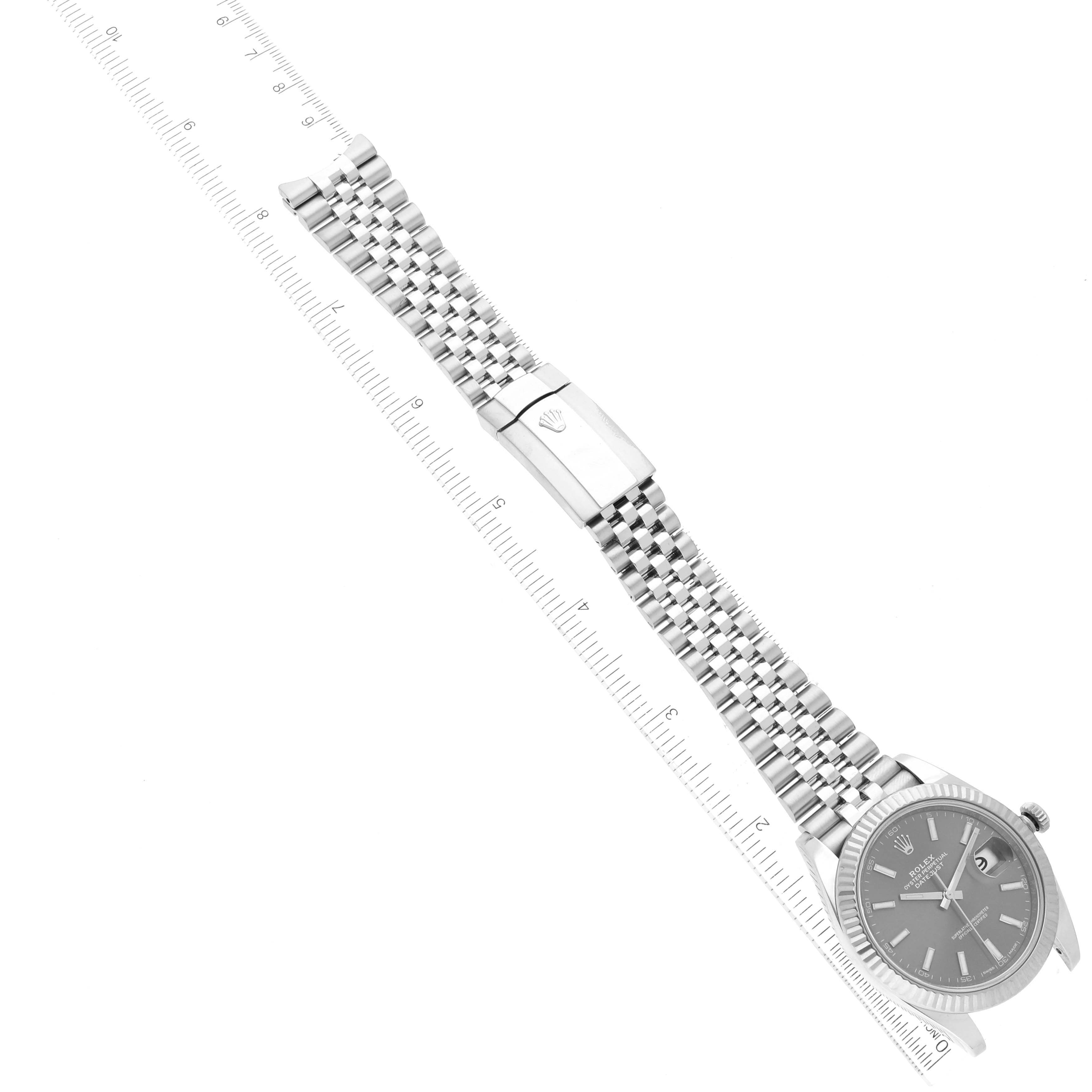 This image shows a Rolex Datejust 41 126334 Men
s Stainless Steel Grey Dial 126334 Men
s Stainless Steel Grey Dial watch at a wide angle, displaying the face, dial, bracelet, and clasp aligned next to a measuring ruler.