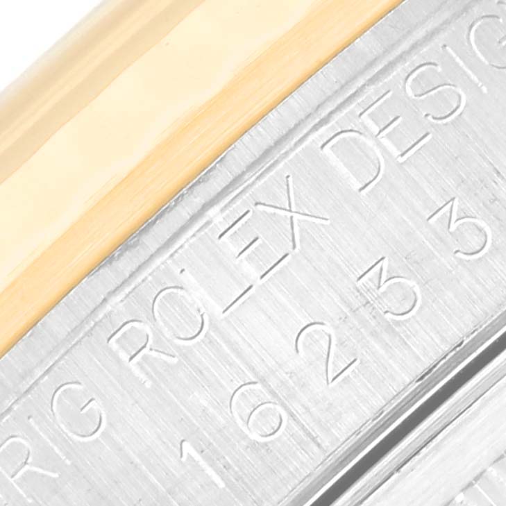 The image shows a close-up angle of the side of a Rolex Datejust 16233 Men's Steel and Gold (two tone) Blue Dial 16233 Men's Steel and Gold (two tone) Blue Dial watch with visible engravings and metal detailing.