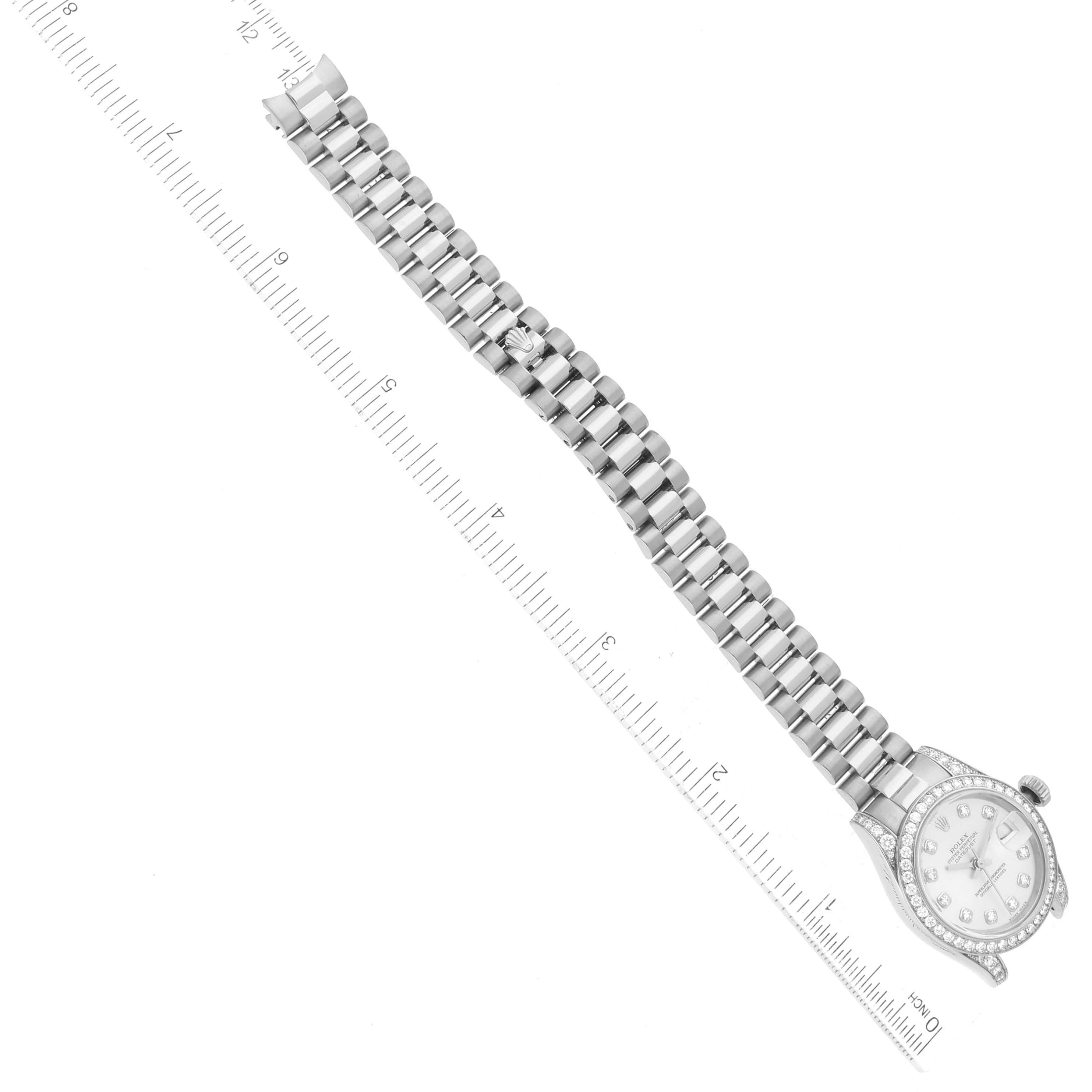The image shows an overhead view of a Rolex President 179159 Women's White Gold Silver Dial 179159 Women's White Gold Silver Dial model watch with the band and face visible along with a measuring ruler.