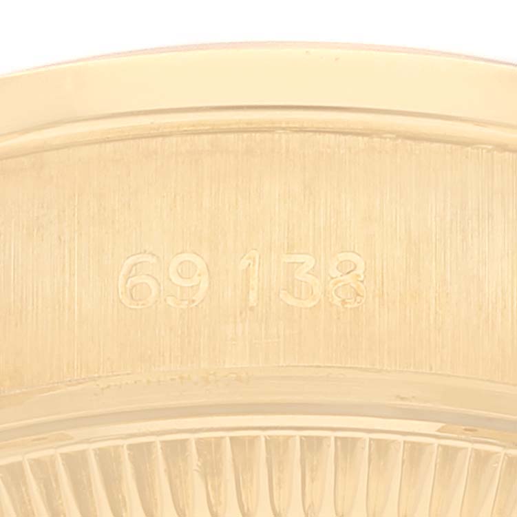 The image shows a close-up of the case back of a Rolex President 69138 Women's Yellow Gold Black Dial 69138 Women's Yellow Gold Black Dial model watch, focusing on engraved numbers.