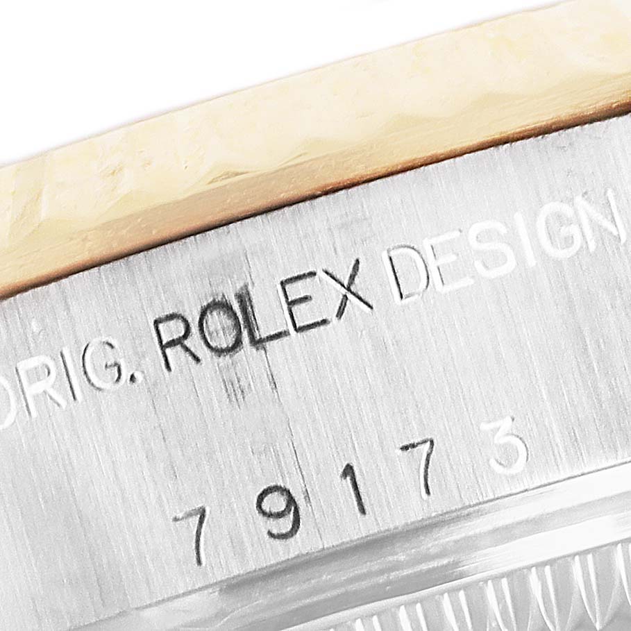 The image shows the side engraving and bezel of a Rolex Datejust 79173 Women's Steel and Gold (two tone) Blue Dial 79173 Women's Steel and Gold (two tone) Blue Dial model.