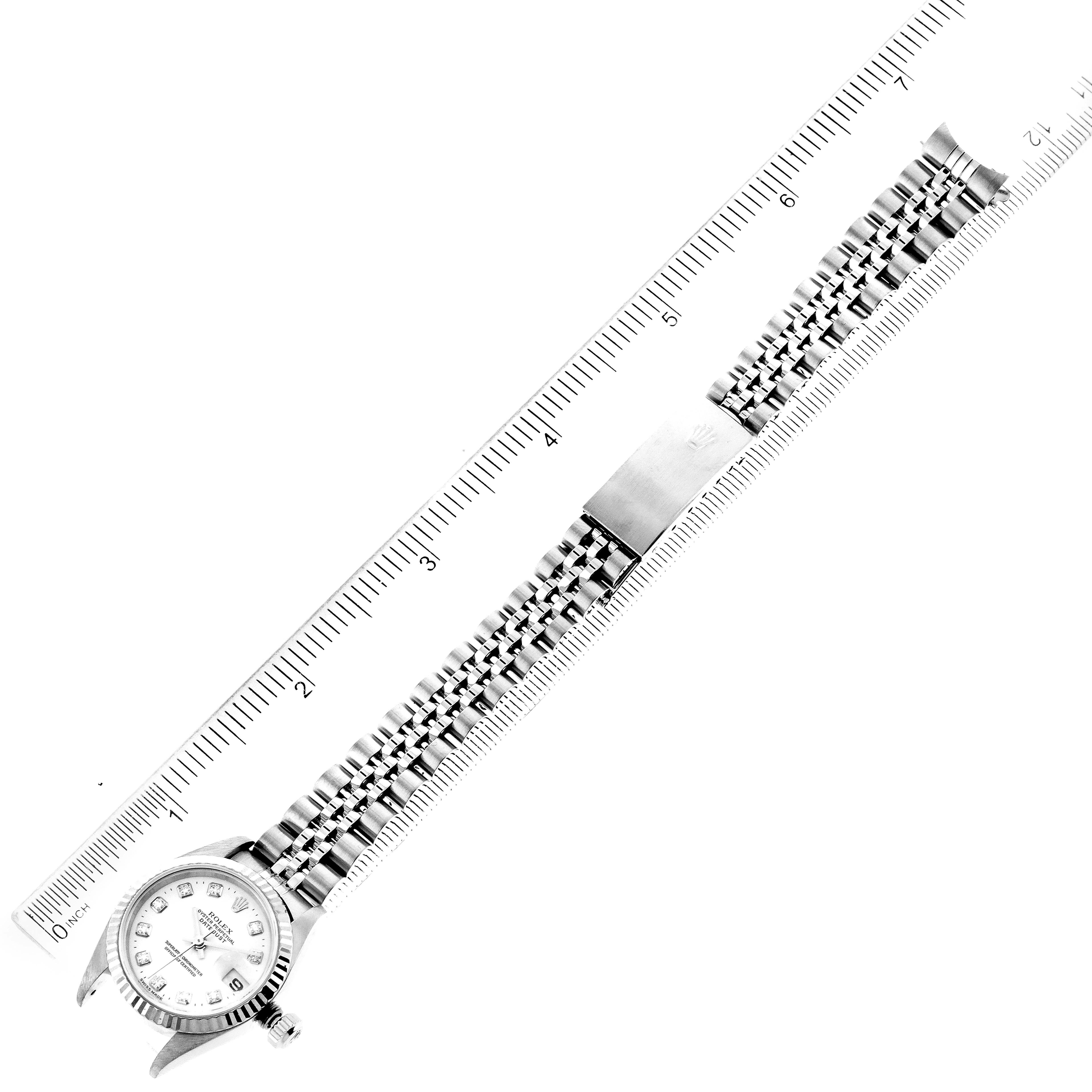 This image shows a Rolex Datejust 79174 Women's Stainless Steel White Dial 79174 Women's Stainless Steel White Dial watch, including its face, bracelet, and clasp, aligned with a measuring ruler.