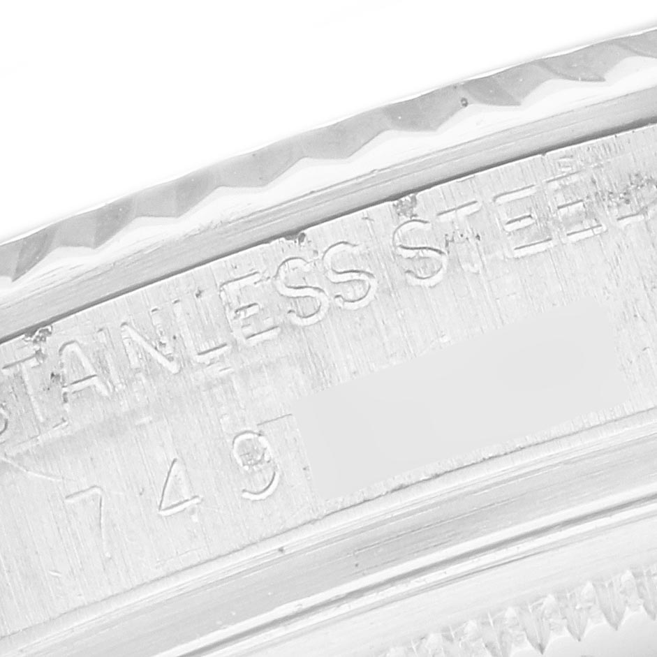 The image shows a close-up of the Rolex Datejust 16014 Men's Stainless Steel Silver Dial 16014 Men's Stainless Steel Silver Dial's bezel and engraved wording indicating "STAINLESS STEEL."