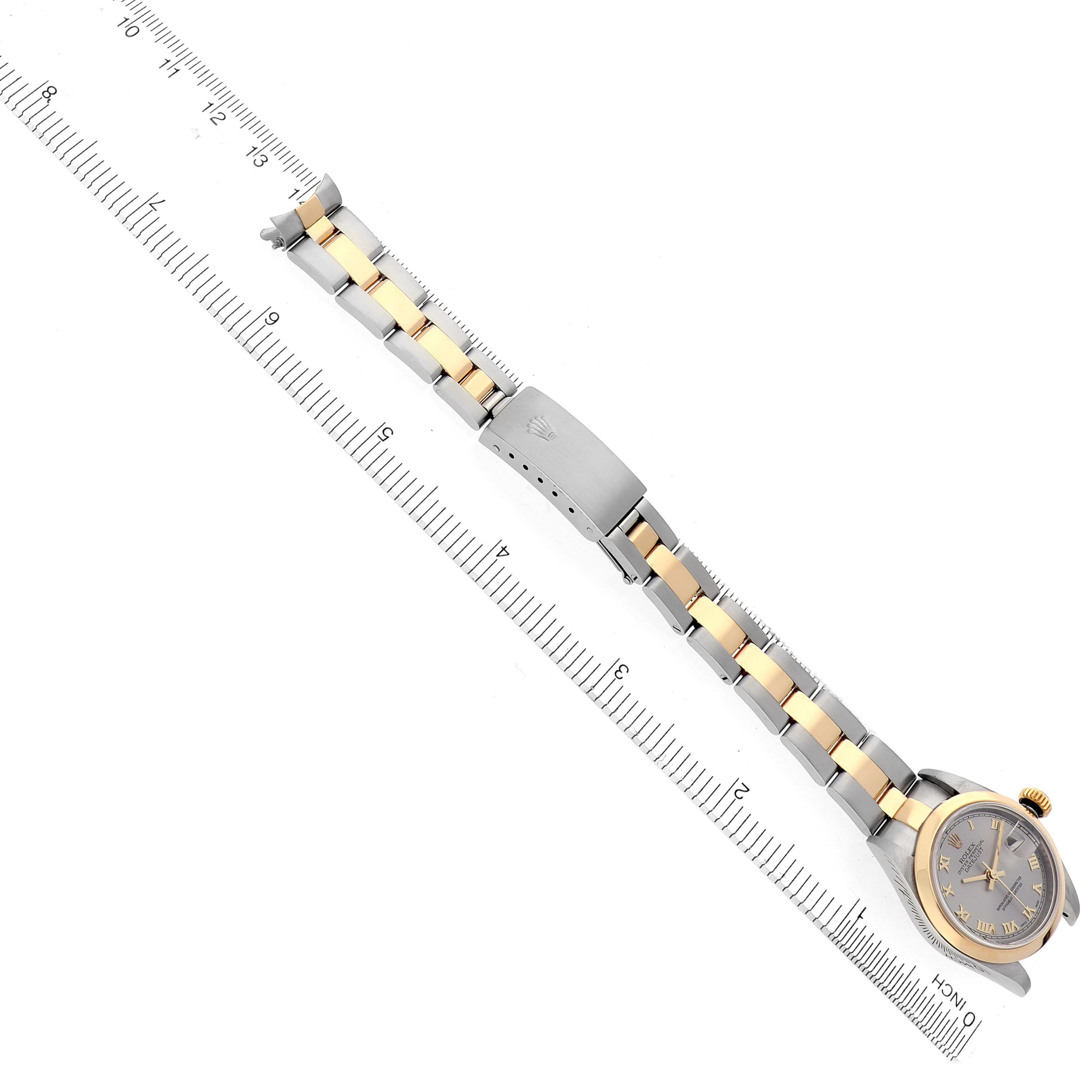 The Rolex Datejust 79163 Women's Steel and Gold (two tone) Grey Dial 79163 Women's Steel and Gold (two tone) Grey Dial watch is shown from an overhead angle, displaying the full bracelet, clasp, and watch face alongside a ruler.