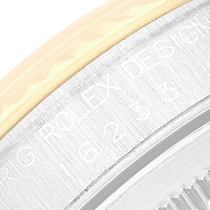 This close-up image shows the bezel and part of the engraved case back of a Rolex Datejust 16233 Men's Steel and Gold (two tone)  16233 Men's Steel and Gold (two tone)  watch.