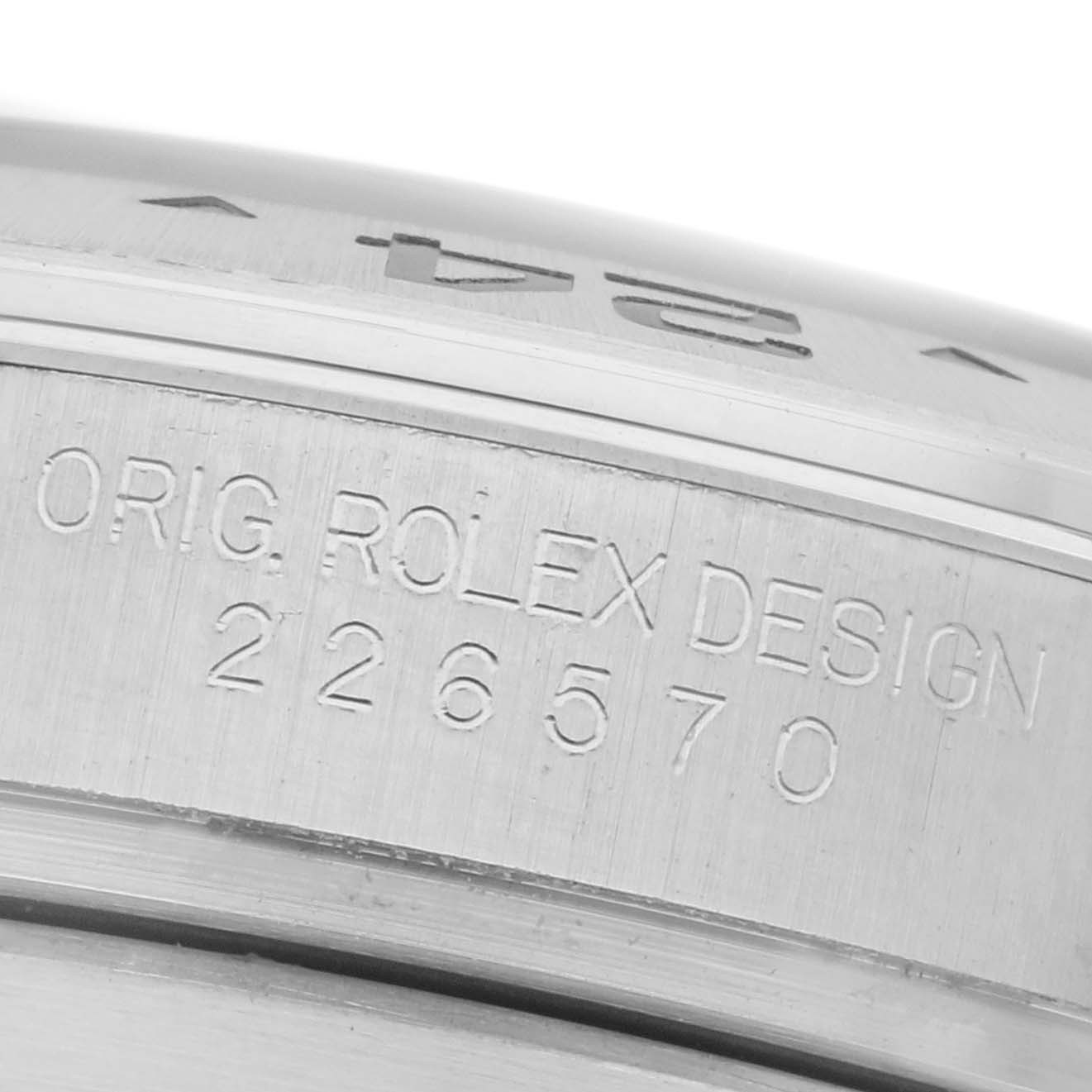 The image shows a close-up of the engraved side of a Rolex Explorer 226570 Men's Stainless Steel Black Dial 226570 Men's Stainless Steel Black Dial, displaying the words "Orig. Rolex Design" and model number.