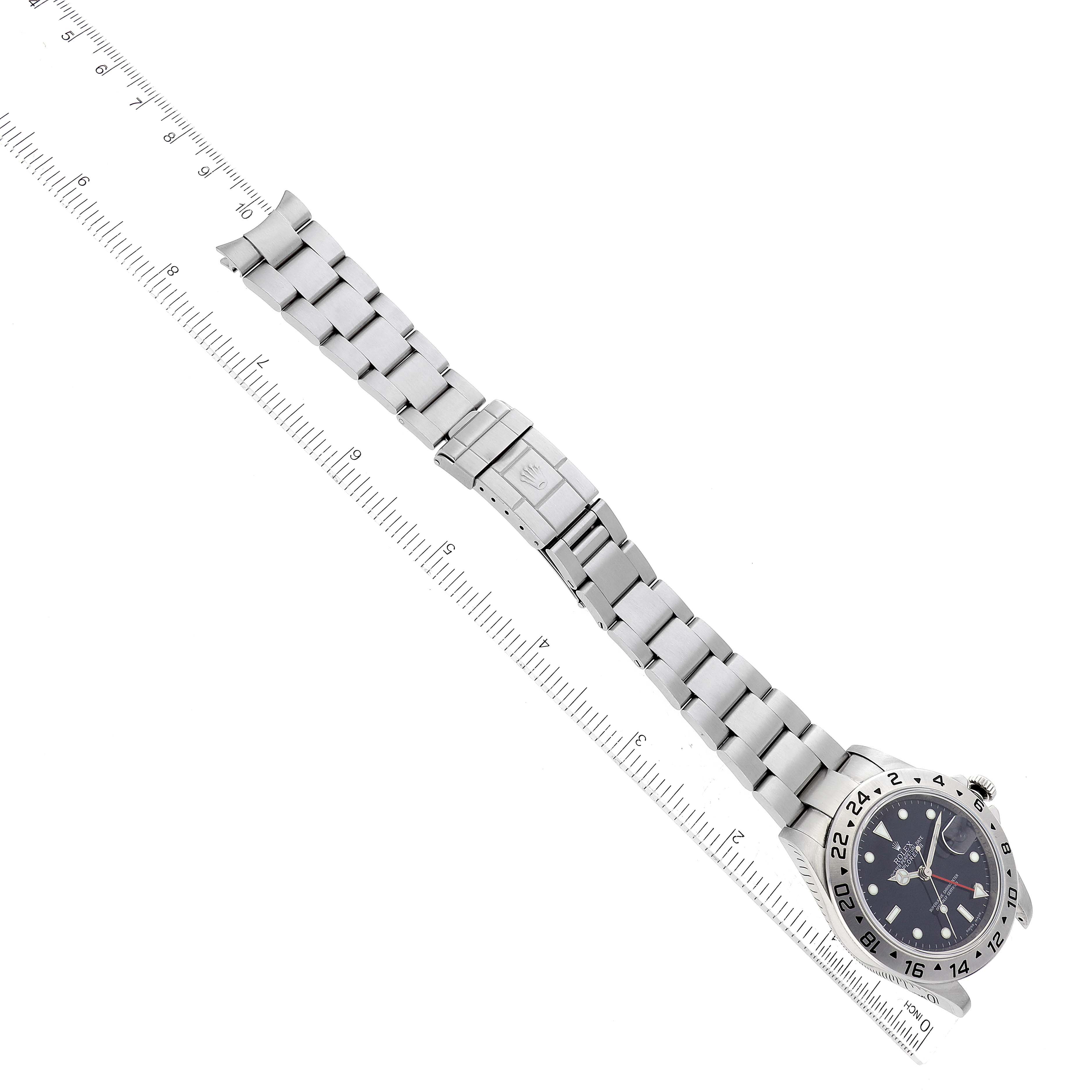 The image shows a side view of a Rolex Explorer 16570 Men's Stainless Steel Black Dial 16570 Men's Stainless Steel Black Dial watch, highlighting the face, bezel, and metal bracelet against a ruler for scale.