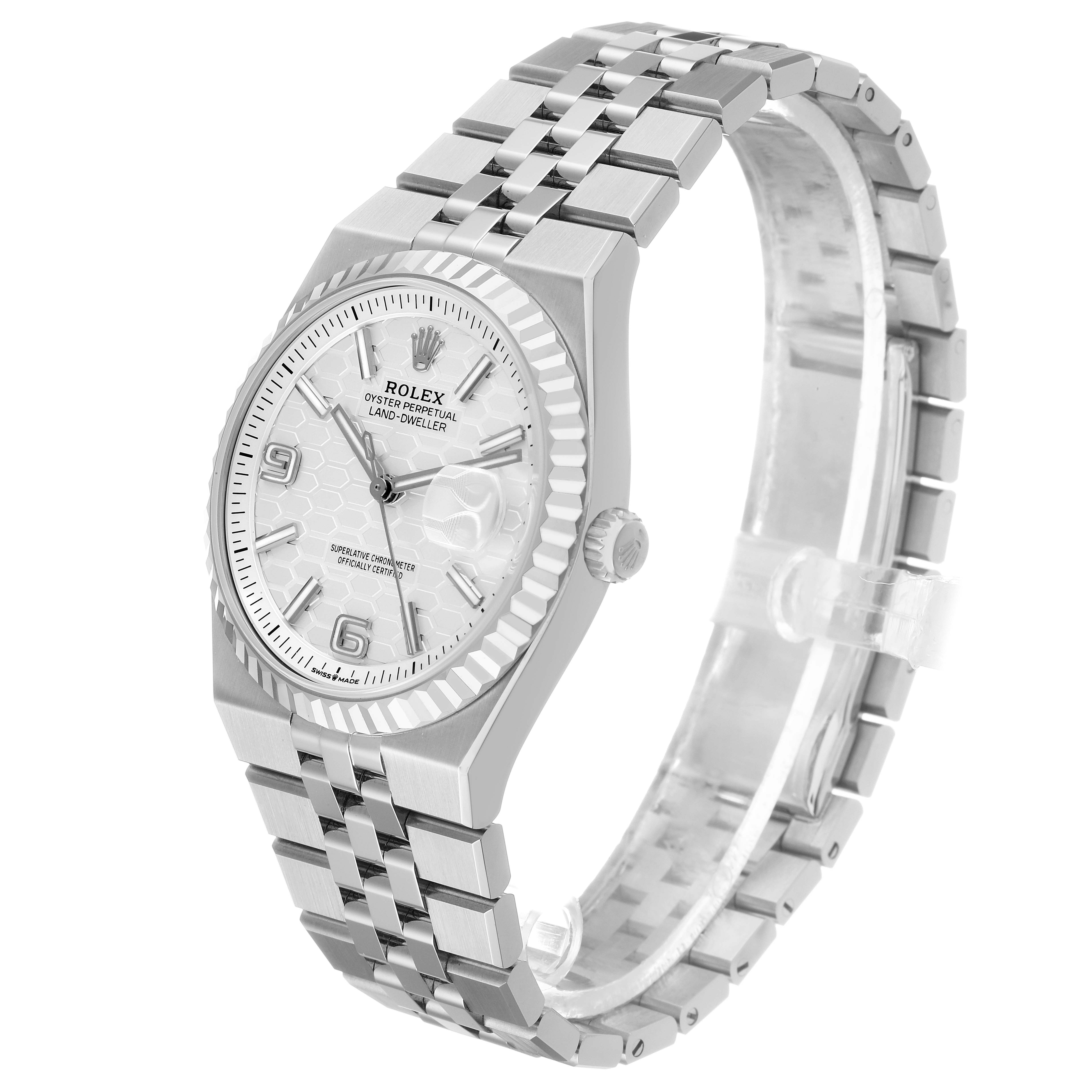 The Rolex Land-Dweller is shown at a slight angle, displaying the face, bezel, and bracelet.