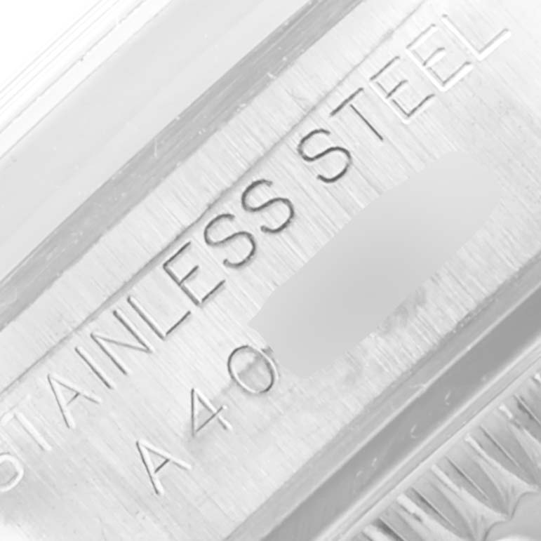 This close-up image shows the engraving and material details on the stainless steel case of a Rolex Oyster Perpetual 76080 Women's Stainless Steel Pink Dial 76080 Women's Stainless Steel Pink Dial watch.