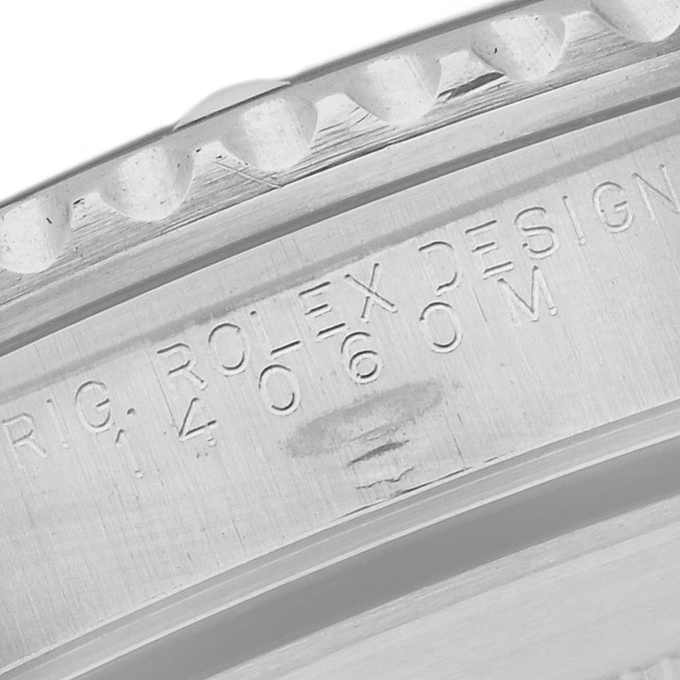 This image shows a close-up of the Rolex Submariner 14060M Men
s Stainless Steel Black Dial 14060M Men
s Stainless Steel Black Dial
s case and bezel, highlighting the engraved model details.
