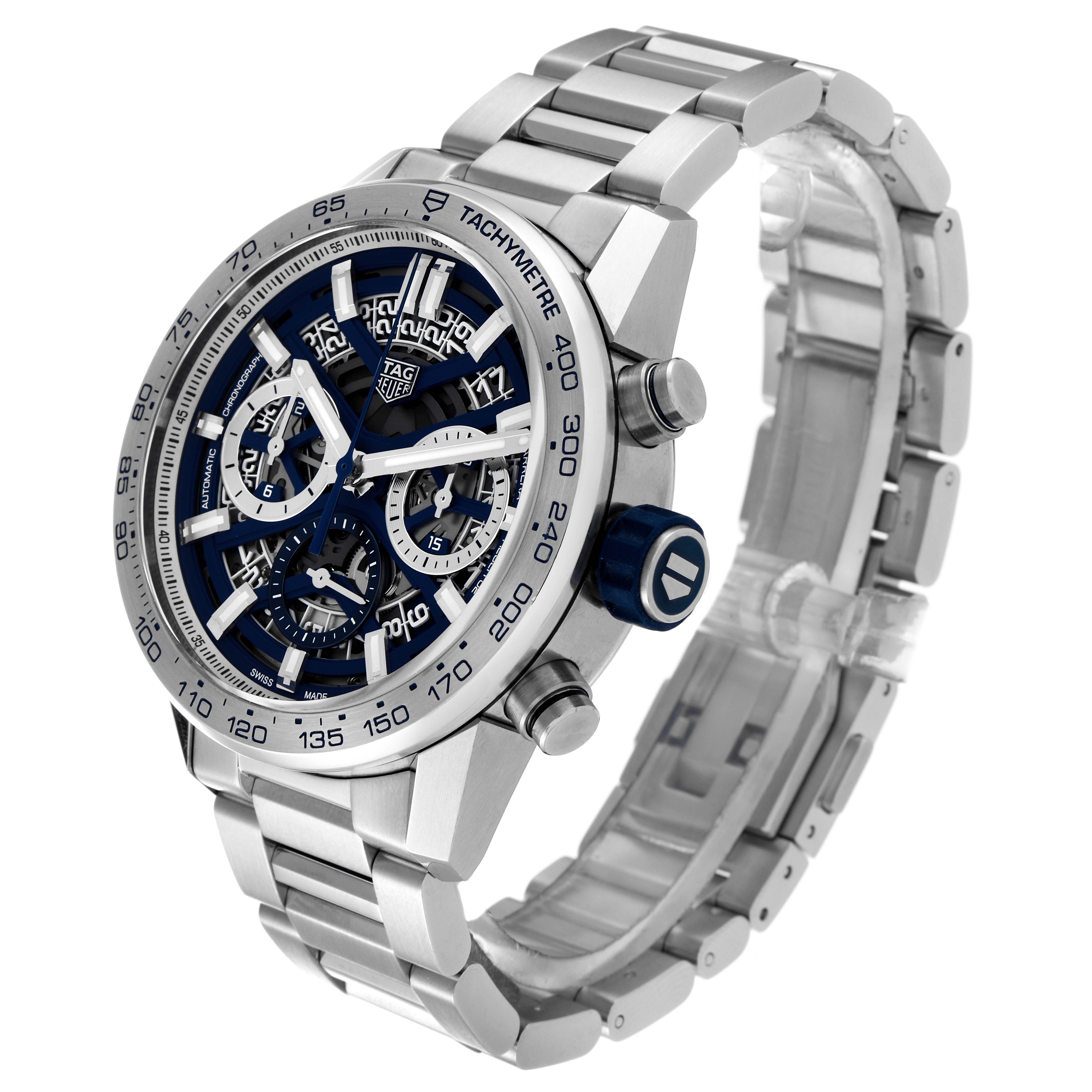 The Tag Heuer Carrera watch is shown at an angle highlighting the face, tachymeter, crown, pushers, and metal bracelet.