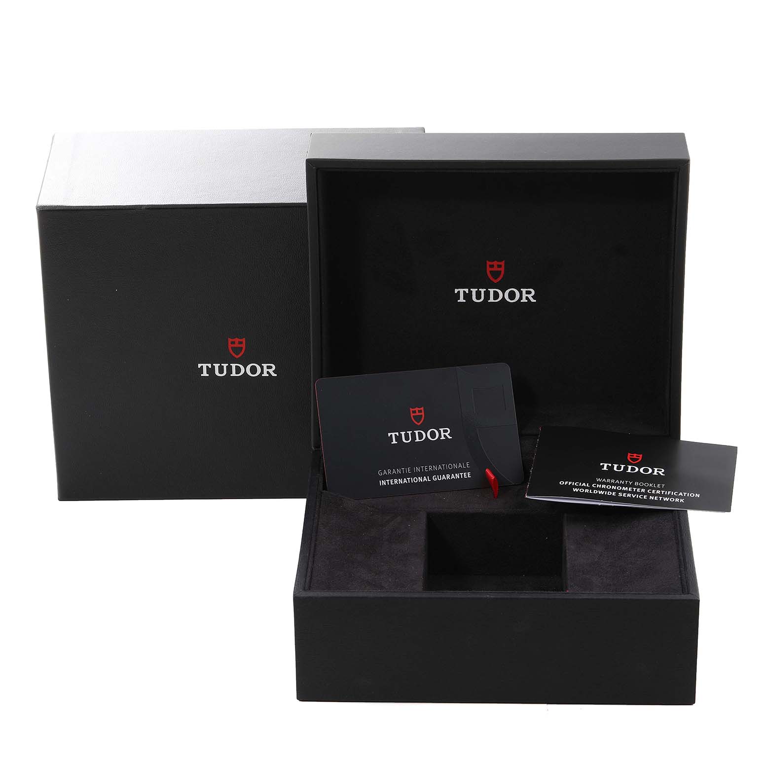 The image shows an open box for the Tudor Sport Chronograph watch, including the warranty card and booklet.