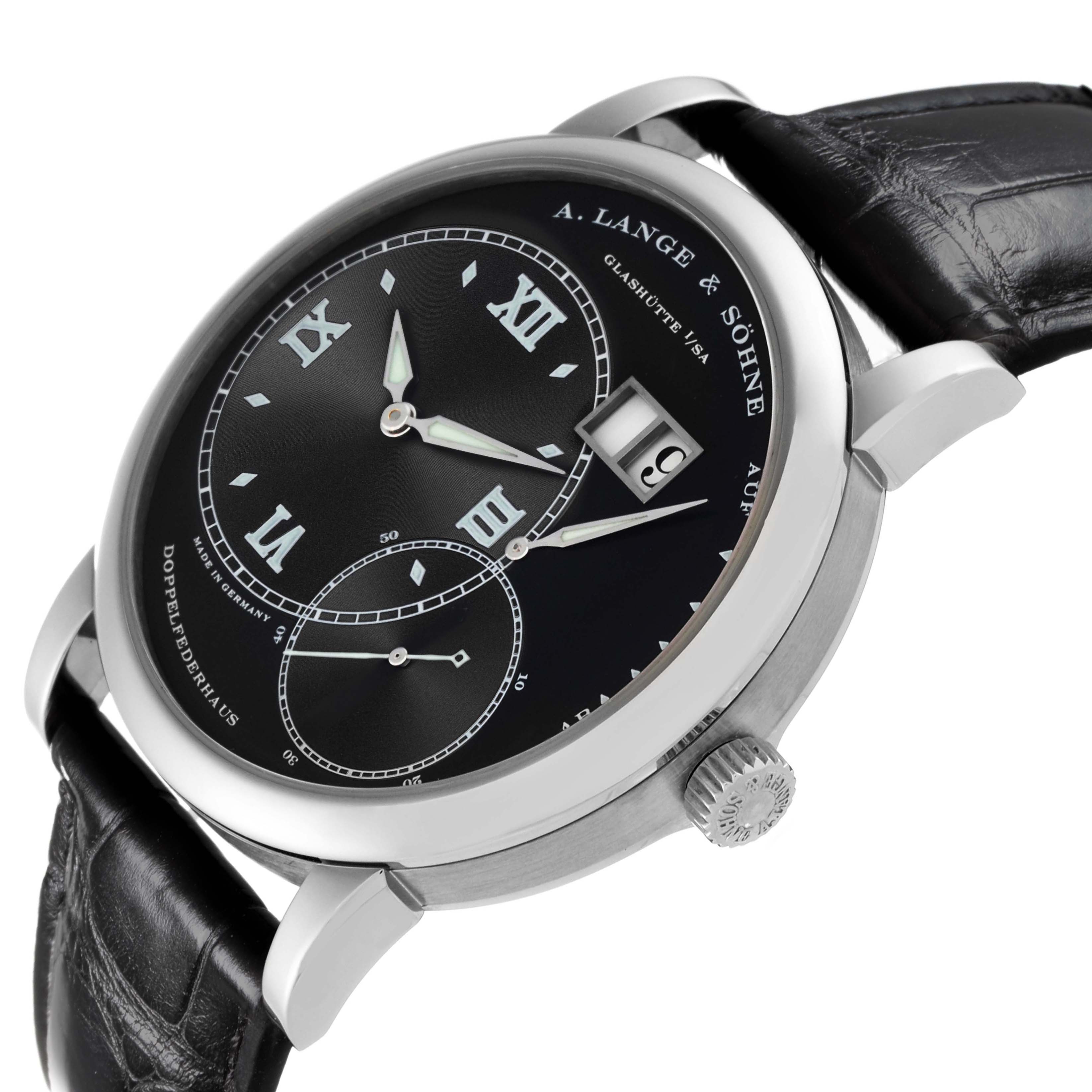 The A. Lange & Sohne Lange 1 115.028 Men's White Gold Black Dial watch is shown from a three-quarter angle, highlighting the dial, crown, and leather strap.
