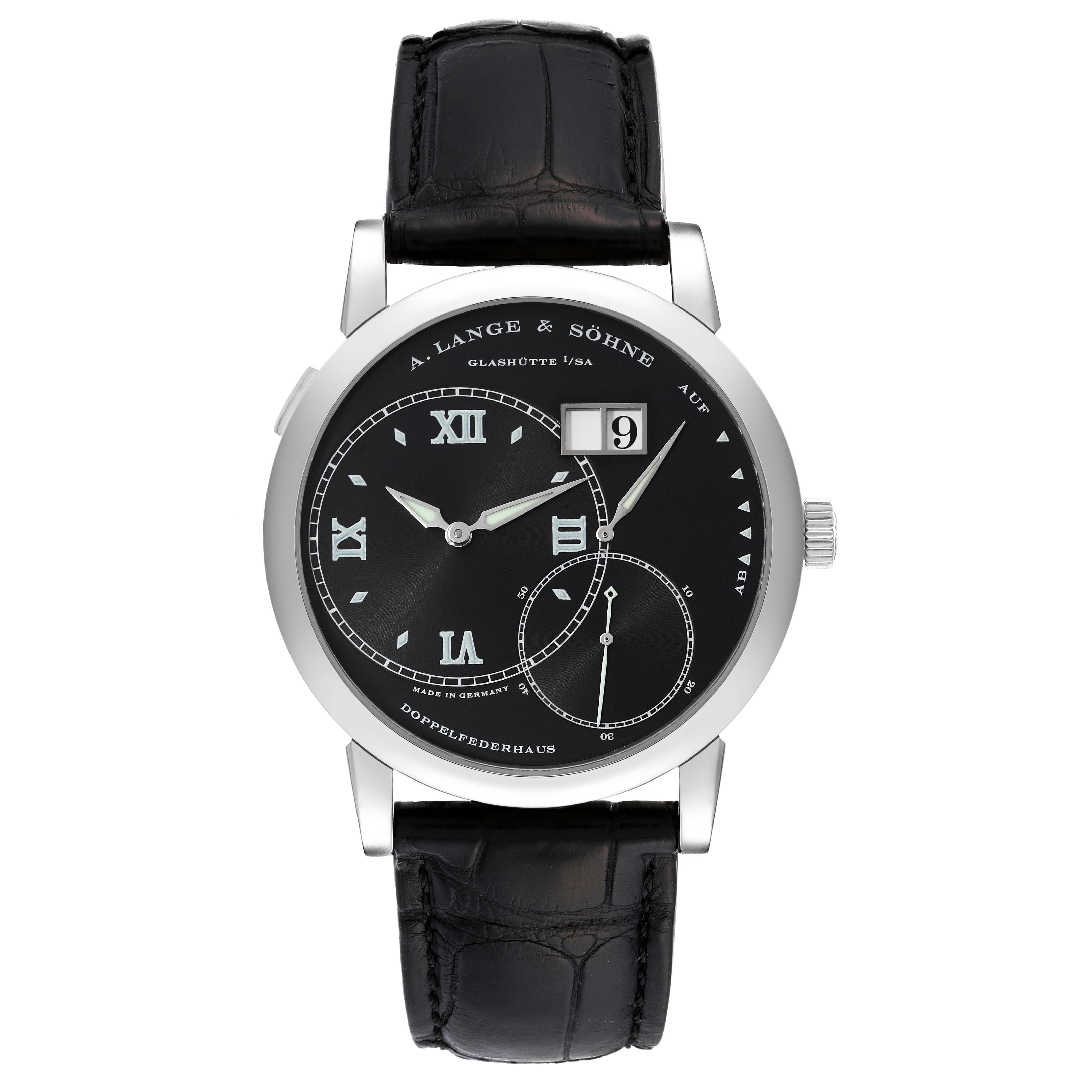 The image shows a front view of an A. Lange & Sohne Lange 1 115.028 Men's White Gold Black Dial watch featuring its dial, hands, date display, and leather strap.