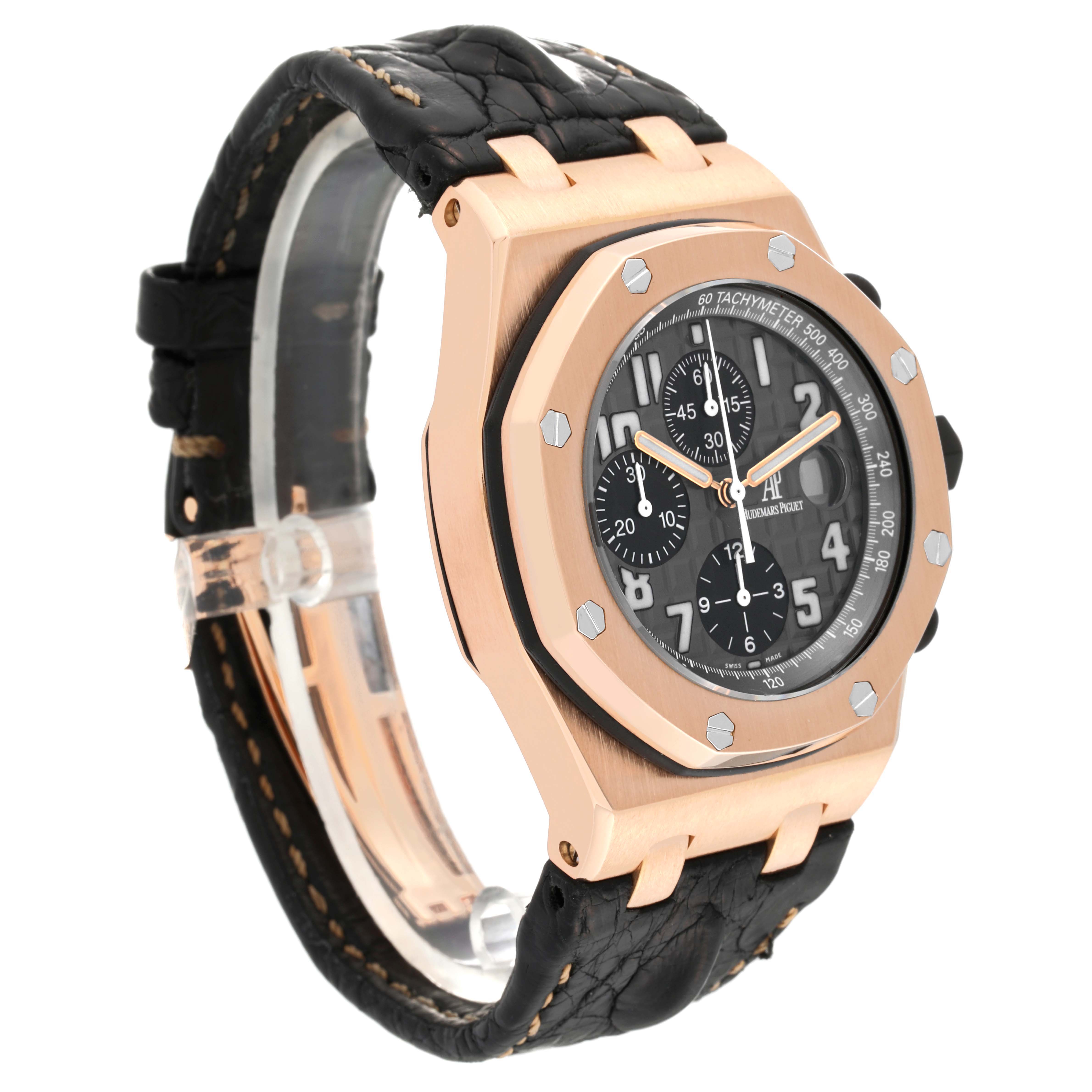 The image shows a side-angle view of an Audemars Piguet Royal Oak Offshore 2590OK.OO.D002CA.01 Men's Rose Gold Grey Dial 2590OK.OO.D002CA.01 Men's Rose Gold Grey Dial watch, highlighting its dial, case, and strap.