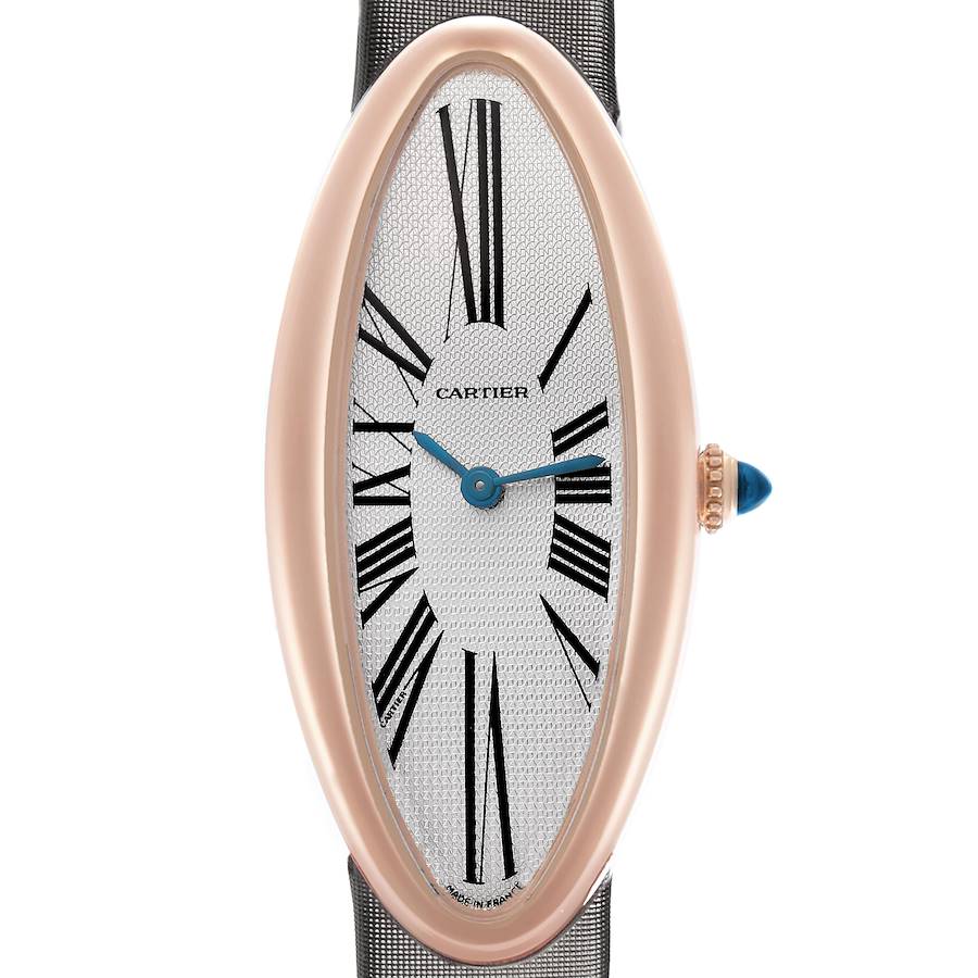 The Cartier Baignoire watch is shown from a front angle, displaying the oval case, Roman numerals, hands, and crown with a blue accent.