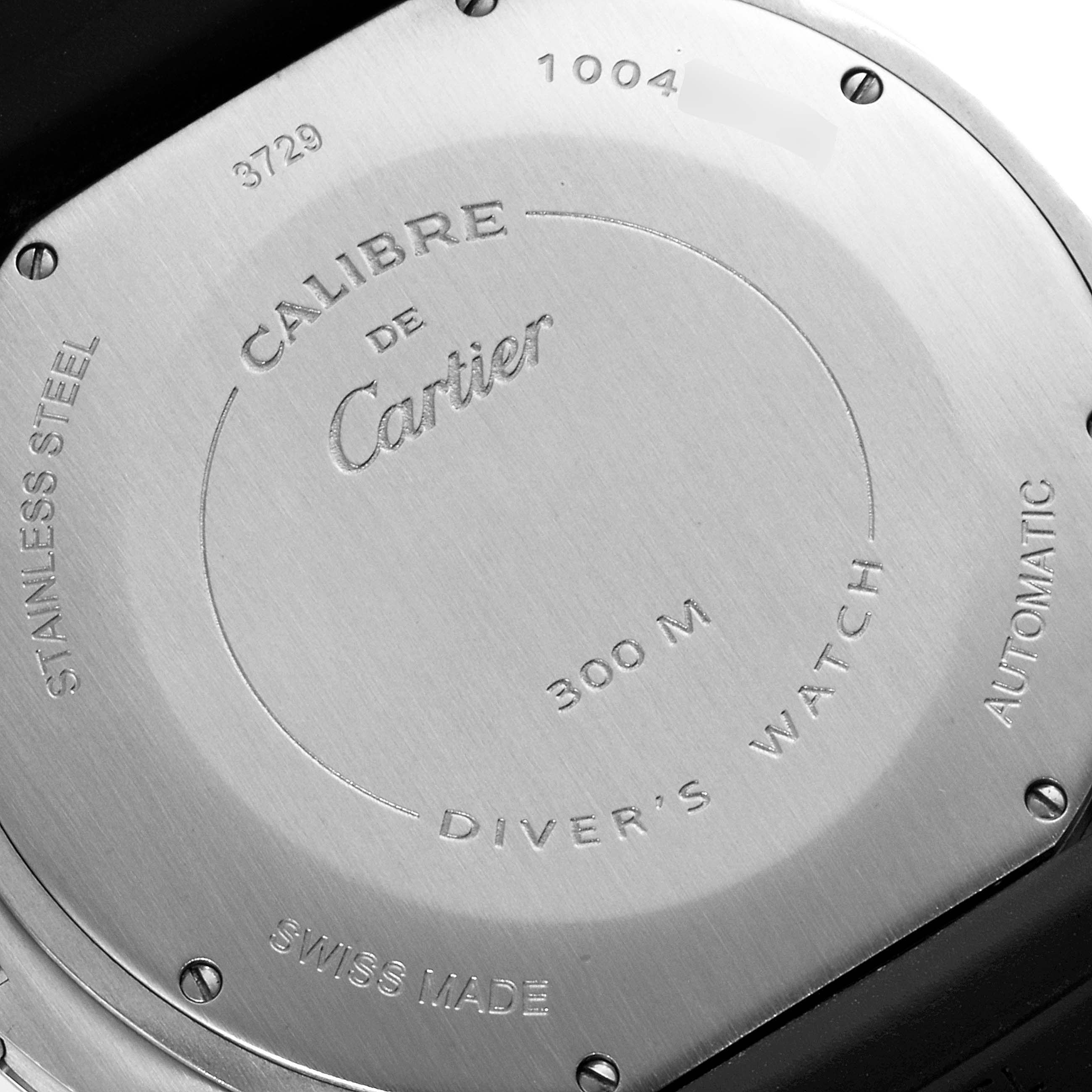 This image shows the back case of a Calibre de Cartier diver
s watch by Cartier, highlighting its markings and screw details.