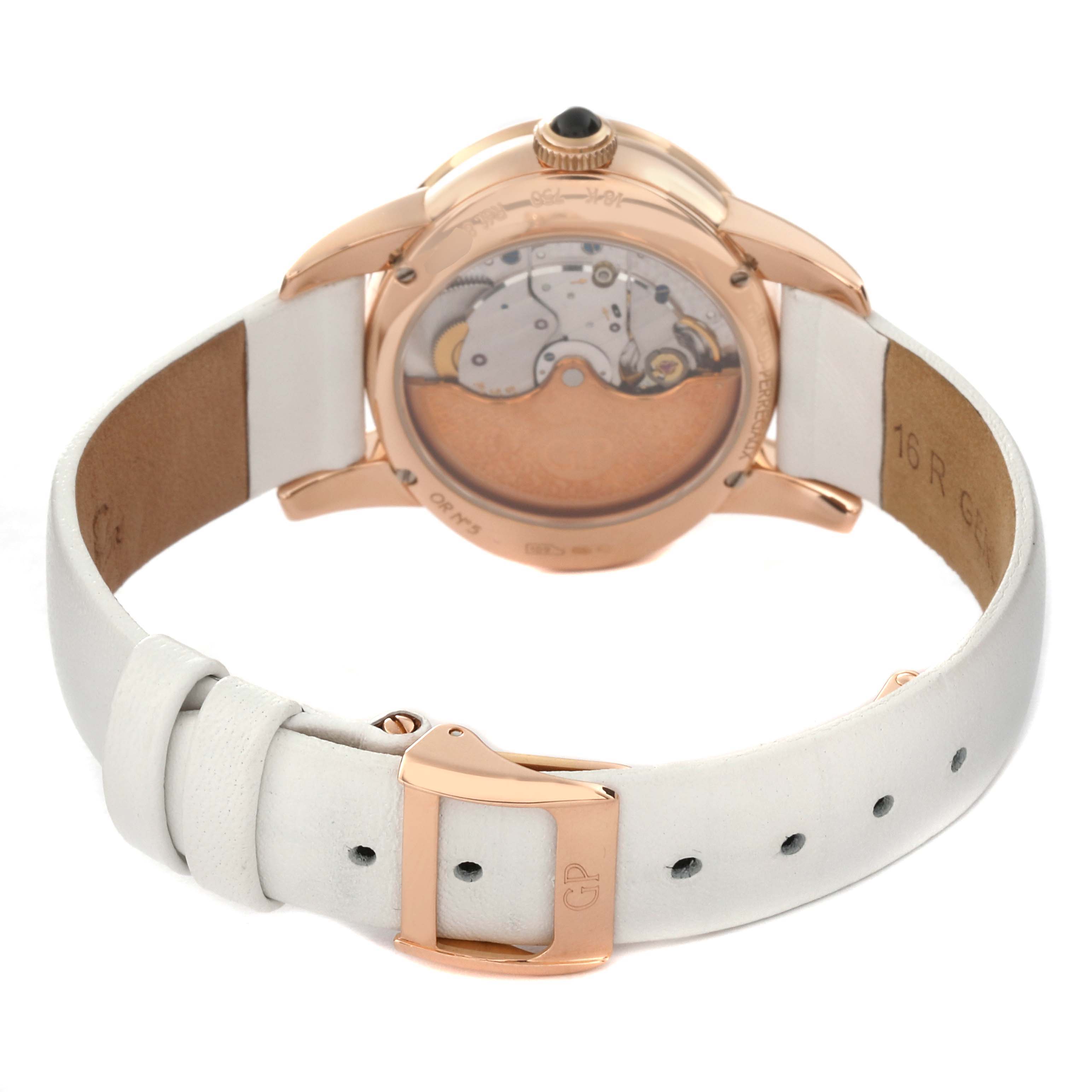 The image shows the back view of the Girard Perregaux Cat's Eye Rose Gold Mother of Pearl Diamond Ladies Watch 80483, focusing on the case back and white strap with a rose gold buckle.