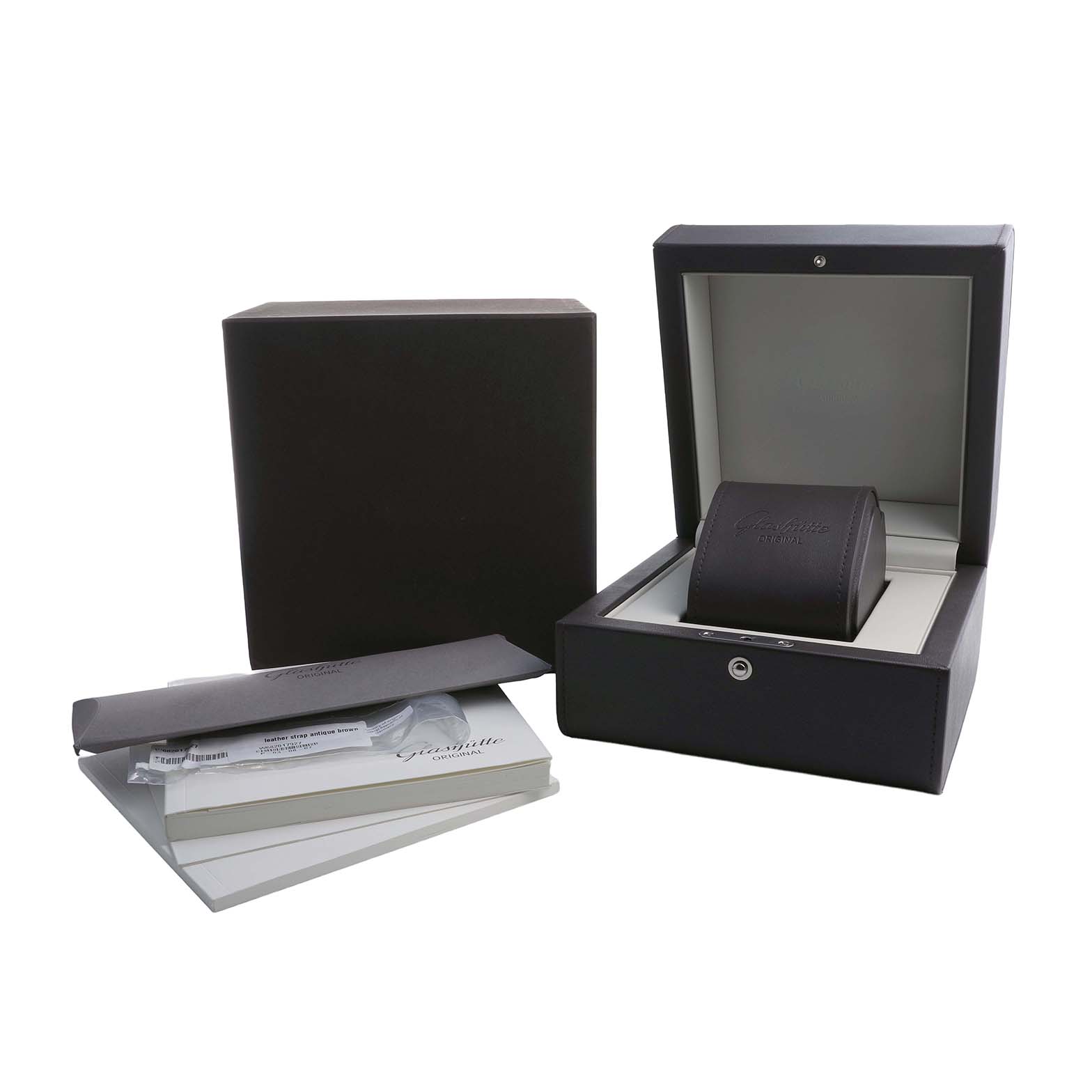 The image shows a Glashütte Pano watch's open box, a protective pouch, and accompanying manuals, displayed at an angle.