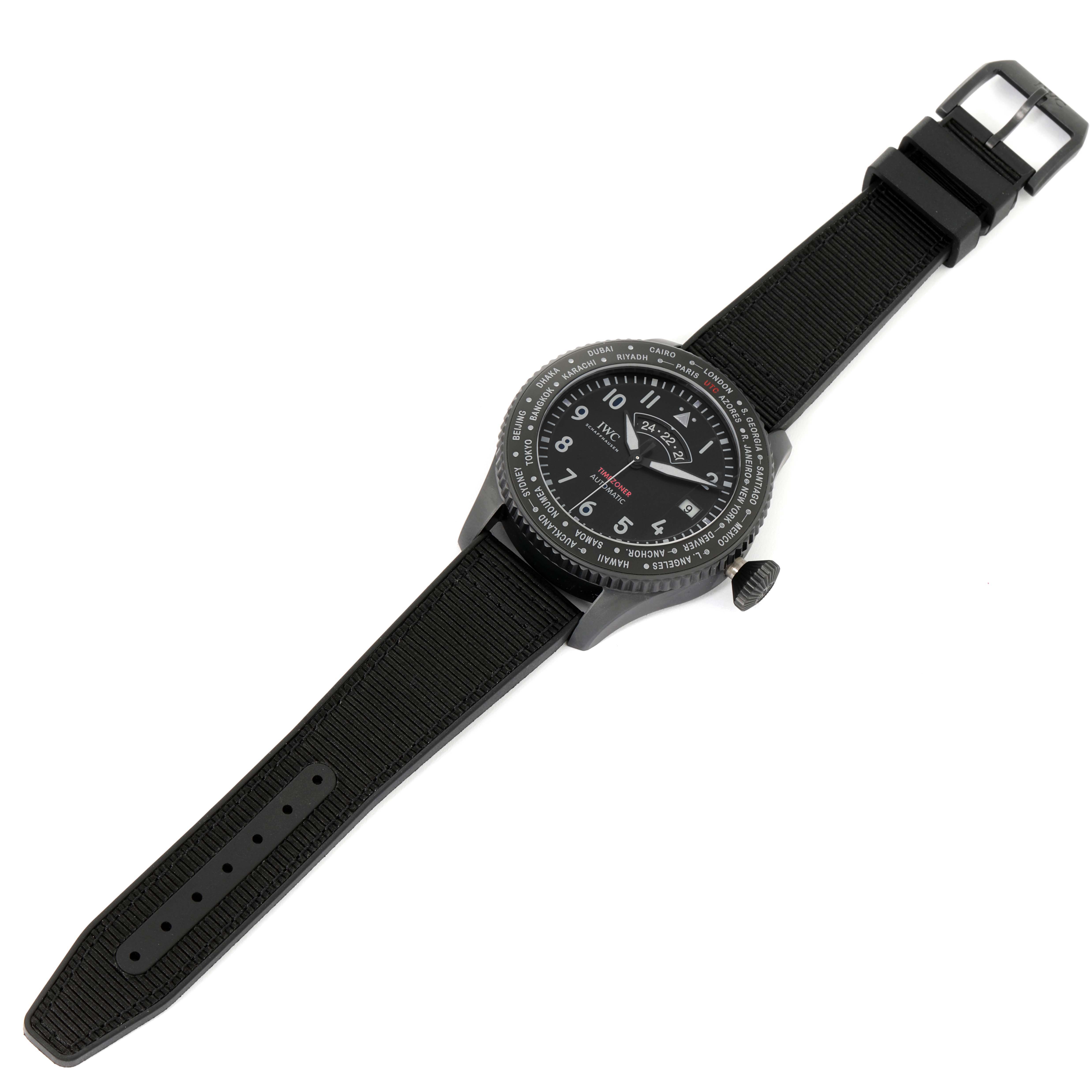 The IWC Pilot IW395505 Men's Ceramic Black Dial IW395505 Men's Ceramic Black Dial model watch is shown at an overhead angle, displaying the black dial, bezel, and black fabric strap with its buckle.